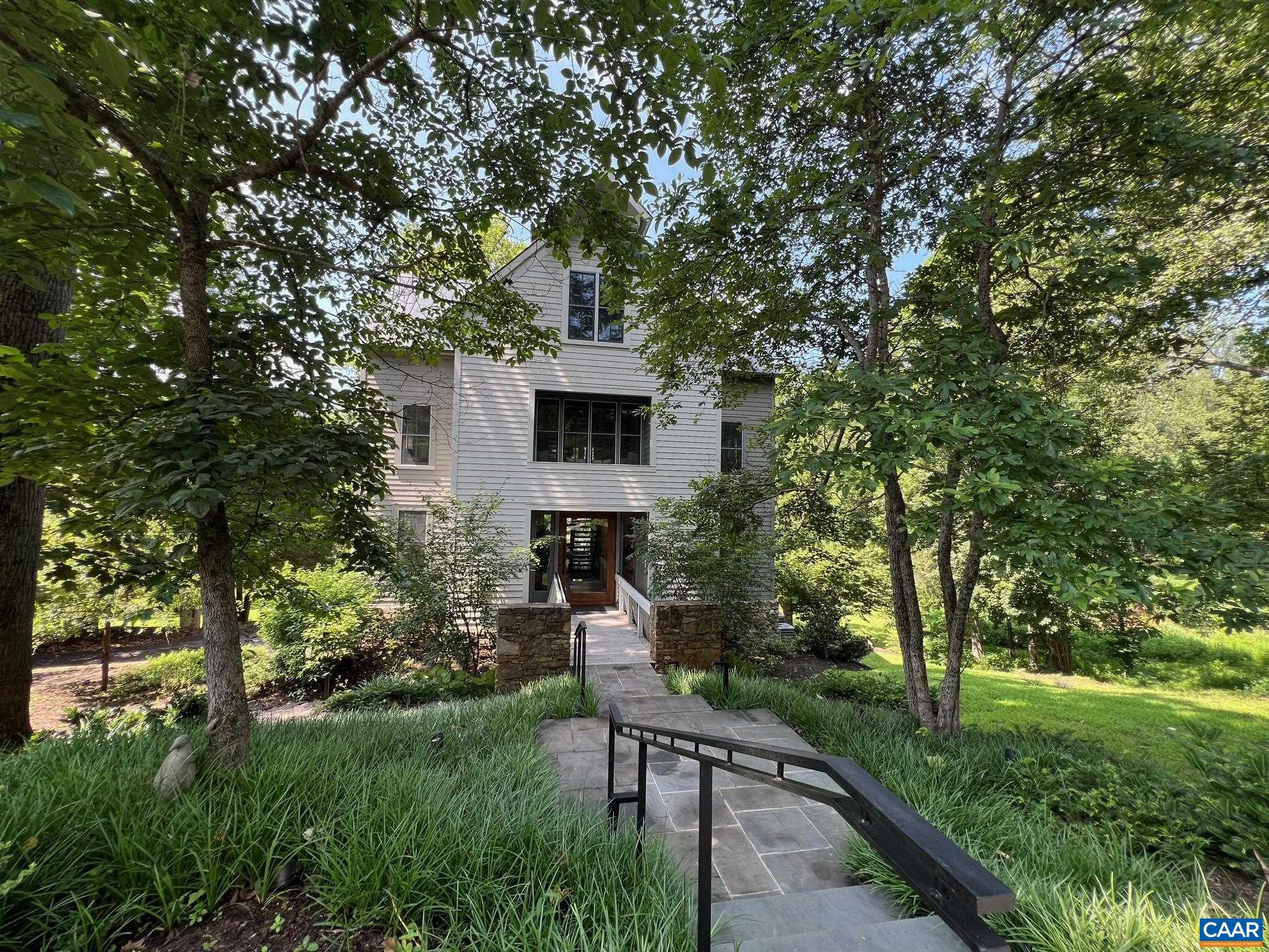 A breathtaking architectural masterpiece in Inglecress, offering nearly 5 acres of luxury, privacy, & natural beauty. Perfectly sited at the end of a peaceful cul-de-sac. Spectacular 4,432SF custom home showcases 4 bedrooms, 3 full and 2 half baths, & a dramatic modern design, fully reimagined by Alexander-Nicholson w/ the finest craftsmanship & materials. Step through a stunning mahogany pivot door into sun-drenched living spaces with soaring ceilings, sleek steel-and-oak staircases, and walls of glass framing endless pastoral and wooded views. The designer chef’s kitchen dazzles w/ Thermador appliances, marble waterfall counters, & custom cabinetry, flowing seamlessly into expansive living & dining areas w/ multiple fireplaces and a NanaWall opening to the elevated deck. Luxury primary suite is a true sanctuary w/ French doors overlooking Ivy Creek & a spa-worthy bathroom. The top floor offers a vaulted guest retreat, while the ground level features a chic family room, wet bar, and 2-car garage. Private elevator, whole-house generator. Relax on elevated deck, gather around the fire pit near the creek, or roam your own park-like grounds w/ direct trail access and 825ft of waterfront.