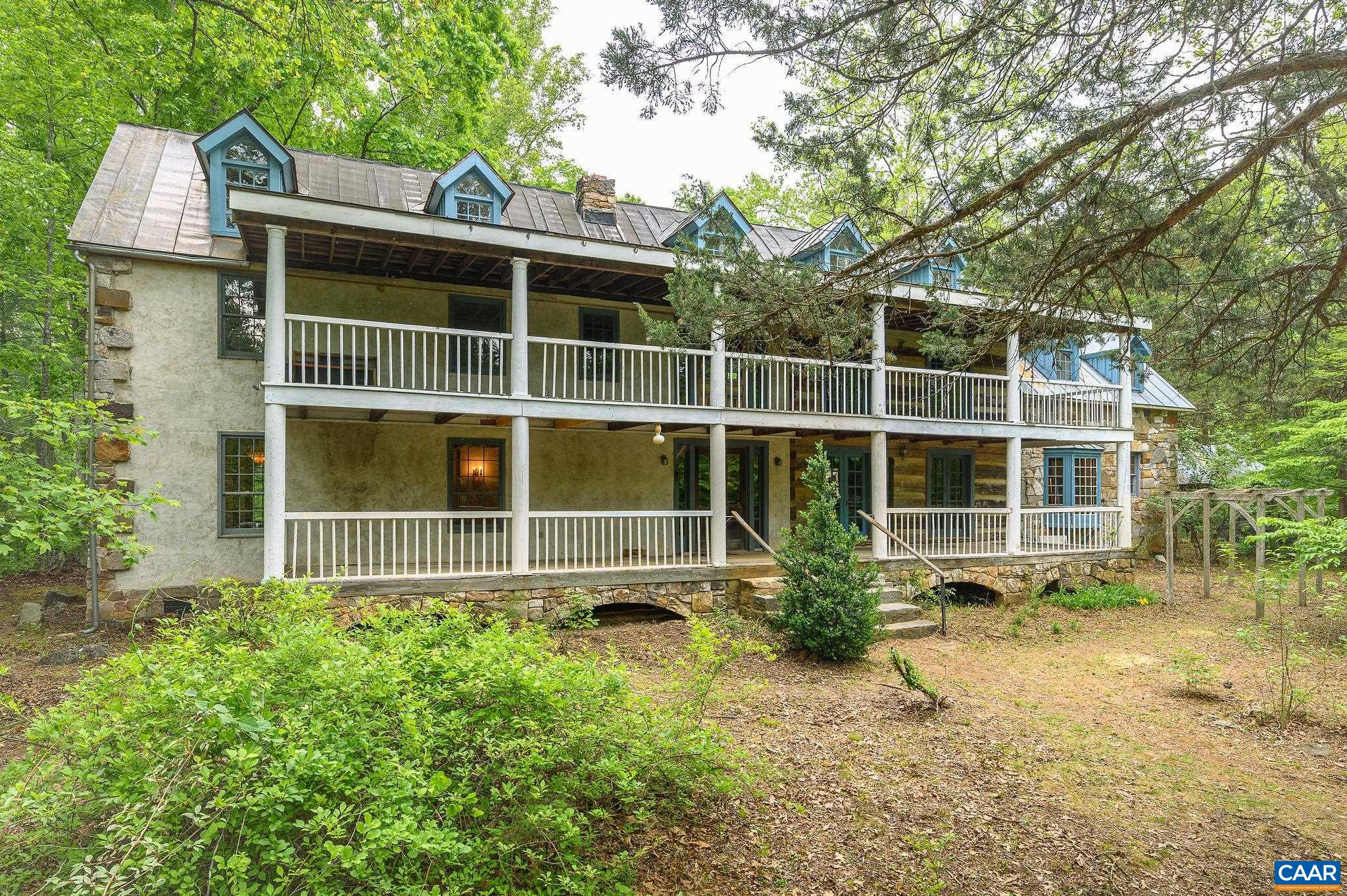 Raven Oak is a rare combination of craftsmanship, history, space, privacy & hidden discoveries built by local builder/craftsman, Charles McRaven. This is McRaven’s hand-crafted, one-of-a kind, home place. With seamlessly married the reclaimed features with the newer parts of the build during construction- 2 hewn log sections & 2 timberframe sections. Much of the structural and finish material is of historic recycled heart pine, chestnut, & heart poplar with the majority of timbers and logs in the house from structures dating from the 1700s and 1800s.  It includes beautiful, intricate stonework constructed with local granite & West Virginia sandstone-there are 2 fireplaces & full chimneys, a notable massive Russian fireplace which heats a large portion of the home, beautiful exterior stonework framing both ends of the house. The kitchen cabinetry of rare American chestnut, copper panels and counter tops, as well as heart pine shelving. On the grounds there are native plantings galore. There are 9 outbuildings including a log chapel that seats 40 people down by the stream. Two additional building rights.  17 beautifully wooded & private acres only 10 mins to the Cville Airport & 23 mins to Cville/UVA.