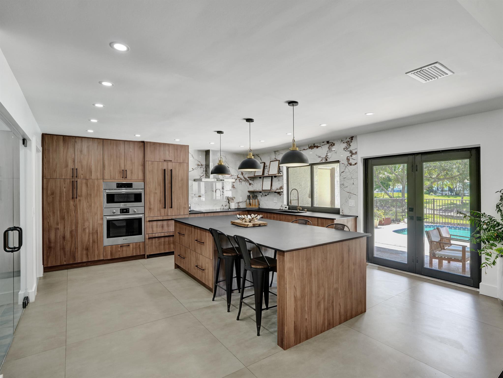 Serenity meets sophistication with this lakeside luxurious, renovated retreat with private pool paradise in Timbercreek -- one of Boca Raton's most picturesque and sought-after communities. Situated on a quiet, tree-lined street off the prestigious St. Andrews corridor, this fully renovated 4-bedroom plus Office, 2 full baths and 2 half-bath oasis offers designer finishes throughout, a 2021 roof, impact windows and doors, and rests on a lush 0.33-acre pie-shaped lot with serene views of a winding lake. Inside, enjoy stunning lake and pool views from nearly every room. The designer kitchen is a showstopper, featuring premium Bosch appliances, a 10-foot Lapitec sintered stone island that's both scratch and smudge proof, custom pull-out cabinetry, a Liebherr refrigerator, and seating for 4 is  ideal for everyday living and entertaining alike.

The main living area boasts vaulted ceilings, a wood-burning fireplace, luxury vinyl flooring, and custom wall paneling that adds warmth and sophistication. Just off the entrance, a statement bar with quartz countertops, a porcelain backsplash, and a wine fridge creates the perfect setting for gathering with friends and family.

The primary suite is a true retreat, offering panoramic lake views, a custom walk-in closet, and a spa-inspired bathroom with floating vanities and porcelain finishes. A glass-enclosed home office provides a stylish and functional workspace, while the home also includes two additional guest baths, a cabana bath, and a powder room. The spacious laundry room features quartz counters, a 2023 Maxx ice maker, and LG washer and dryer for added convenience.

Additional upgrades include a 2021 electric panel, 2021 HVAC system, 2019 hot water heater, a 2-car garage, and mature mango trees that add charm to the beautifully landscaped lot. Timbercreek offers community parks, scenic lakes, bike paths, basketball courts, playground, gazebo, abundant wildlife, community events with food trucks, all with a low HOA and no rental restrictions.

Located just minutes from Boca's top-rated schools, pristine beaches, Town Center Mall, Mizner Park, 5 star dining, shopping, medical facilities, and convenient for commuters with major highways (I-95 and the Turnpike), this home offers a rare blend of modern luxury and natural beauty... truly a place to call home.