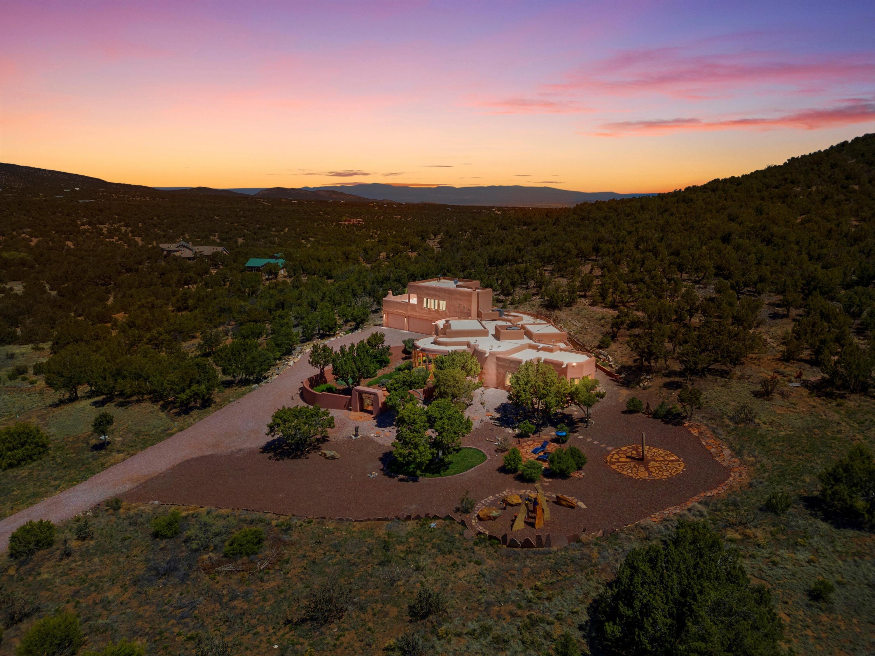 ** Where the spirit of New Mexico's artistic and literary legends lives on. Step into a truly unique home where the timeless artistry of Georgia O'Keeffe and the grandeur of the the Southwest is alive in every detail.28 Canon Escondido is not merely a home--it's a living narrative, a tribute to Northern New Mexico's magical realism, storytelling traditions, and deep connection to land and sky. Surrounded by soaring mountains and tree rich terrain, the contrast of the rugged landscape and the luxury of a stunning home and estate will leave you breathless each day. This Northern New Mexico Pueblo-style sanctuary has been lovingly hand-crafted with the highest attention to detail. From the hand-chiseled doors and kiva fireplaces to clay plaster walls, Mexican Saltillo tile, ..(Continued..