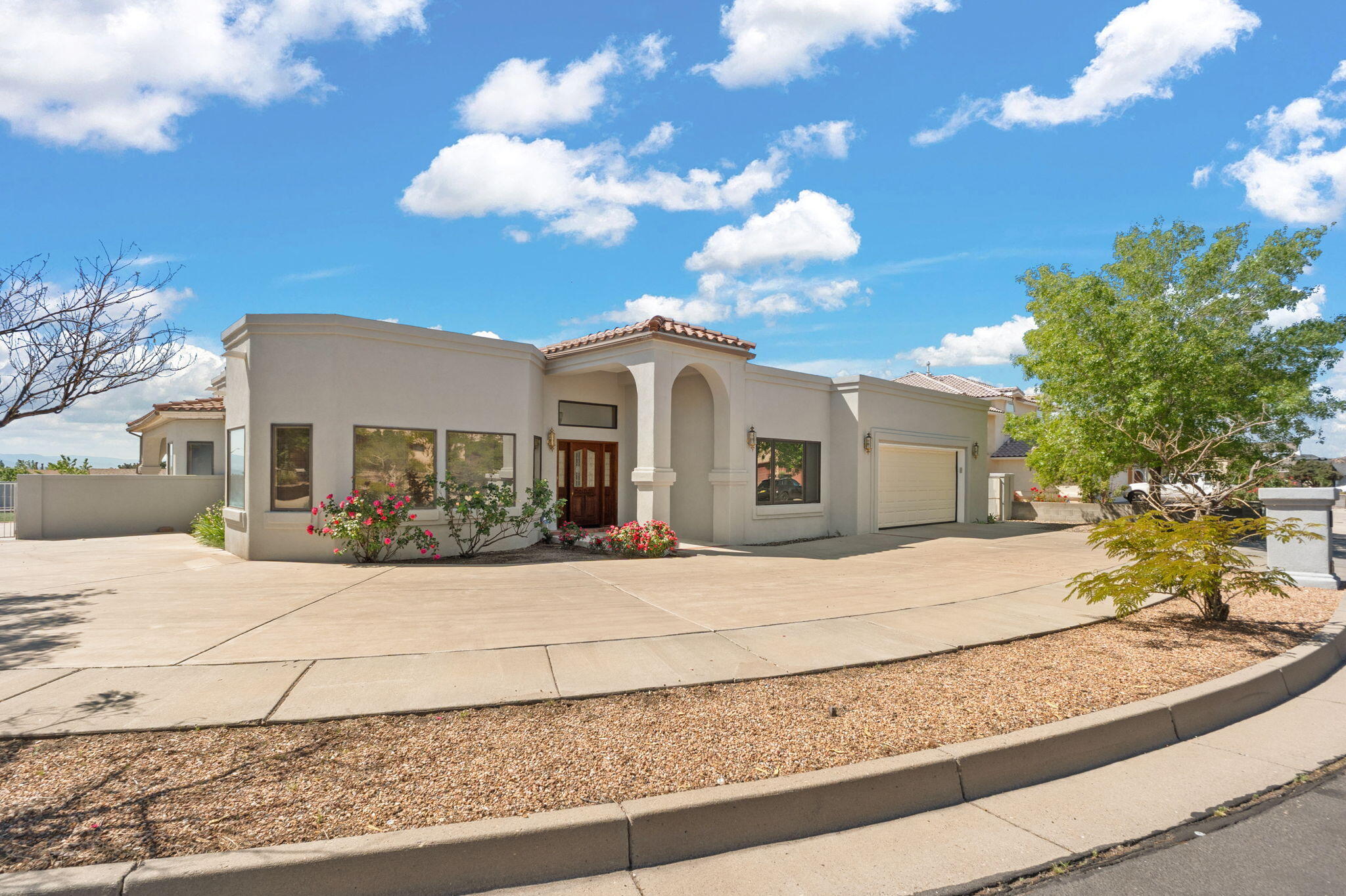This stunning 3,150 sqft custom home sits on a private 0.25-acre corner lot, offering 5 bedrooms, 2 baths, and a dedicated office. Elegant details include soaring ceilings, wood beams, Italian tile floors, and abundant natural light from Pella windows and skylights. The chef's kitchen boasts premium appliances, custom cabinetry and breakfast nook, while the great room features a cozy gas fireplace. The primary suite is a retreat with an en-suite bath, dual walk-in closets, and patio access. Outside, Southwestern charm meets durability with a tile/TPO roof and arched entry. Enjoy an oversized driveway, low-maintenance landscaping, rose bushes, mature trees and a private backyard with a covered patio, backyard access, and stuccoed storage shed.