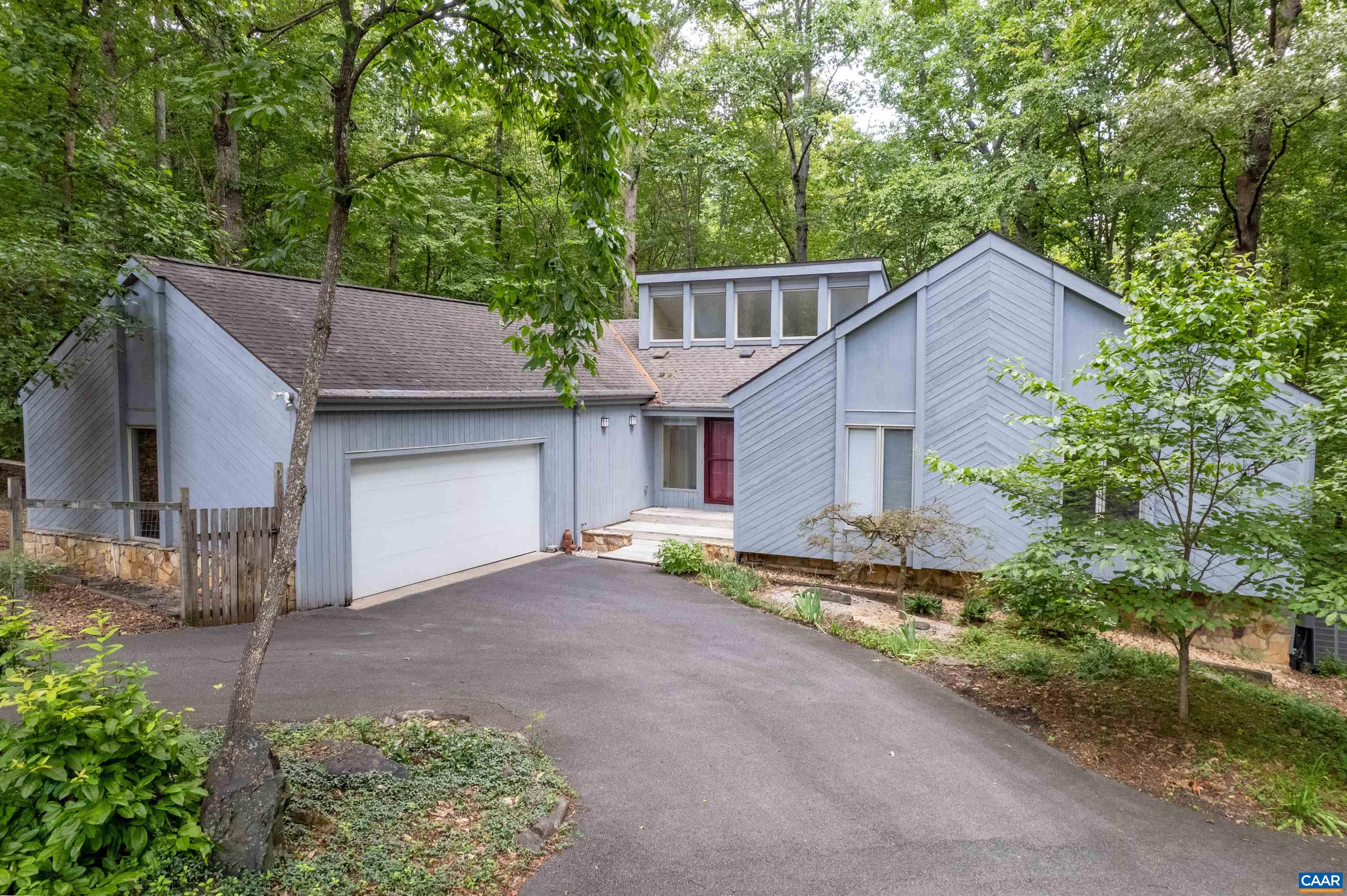 Nestled on a private 2.4-acre lot and surrounded by the serene beauty of Ivy Creek Natural Area, this generously sized 5-bedroom, 3.5-bath contemporary home offers modern comfort and natural charm. Step inside to discover beautiful heart-pine hardwood floors, a light-filled living room anchored by a dramatic floor-to-ceiling wood-burning stove, and expansive woodland views from every main-level room. Enjoy outdoor living on the wraparound deck, ideal for morning coffee or evening gatherings. The lower level offers incredible flexibility with a large family room, additional bedroom and full bath, home office, and a workshop—perfect for work, guests, or hobbies. With direct backyard access to Ivy Creek Natural Area you’ll enjoy nature just steps from your door. Conveniently located near Whole Foods, Trader Joes & UVA, this home is a rare find combining privacy, space, and accessibility.