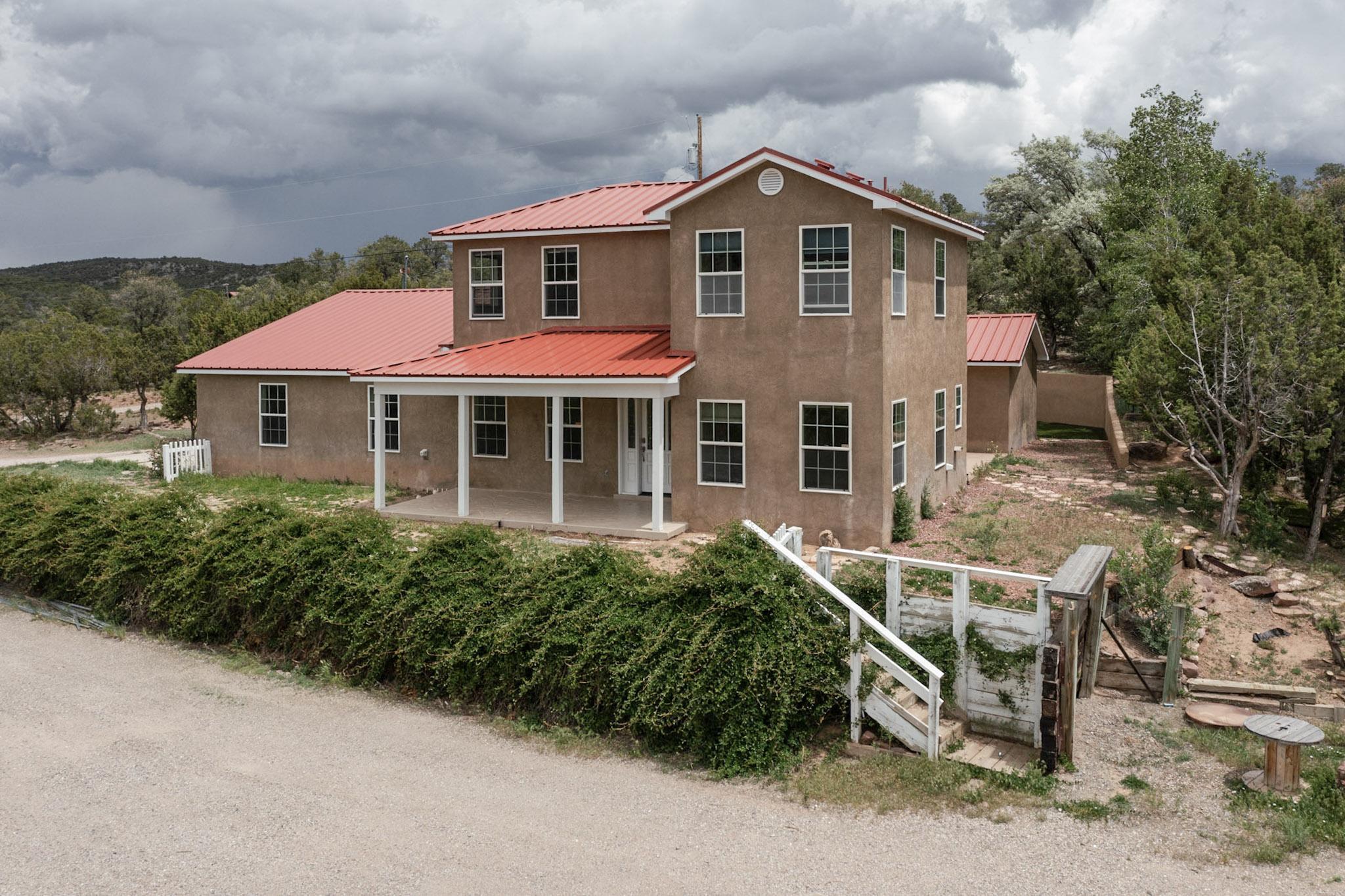 Discover the perfect blend of privacy, space, and stunning scenery in this 3,200+ sq ft custom home located in scenic Tijeras, New Mexico. Just 10 minutes from Albuquerque, this 4-bedroom, 3-bathroom home offers the tranquility of country living with the convenience of city access.Perched on an elevated lot behind gated access, this property boasts phenomenal views of the Sandia Mountains and surrounding high desert landscape. From sunrises to starry nights, the vistas are truly unforgettable and visible from nearly every room.Inside, the home has been freshly painted and features a mix of tile, engineered hardwood, and carpet flooring. Multiple living spaces provide flexibility for entertaining or relaxing, including a spacious family room, formal living area, and dining room.