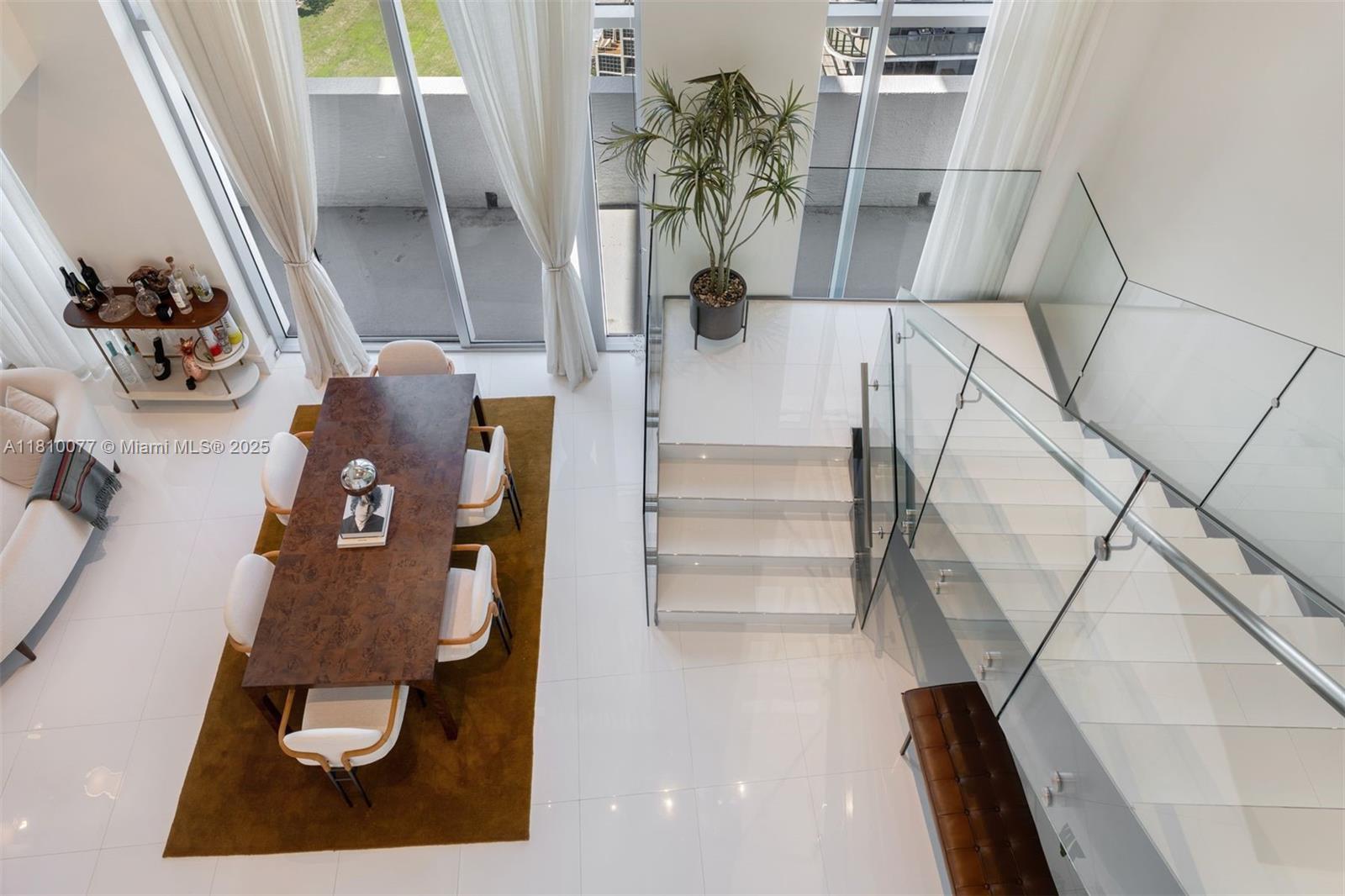 A rare two-story penthouse, offering over 2,400 square feet of thoughtfully curated interiors, soaring 20-foot ceilings and expansive floor-to-ceiling impact glass that frames breathtaking bay and city vistas Bathed with natural light, the open-concept layout serves as an ideal canvas for art collectors and creatives, highlighting every piece beautifully with gallery-like clarity. 3 beds plus a den, and 3 full bathrooms, flowing effortlessly into a sleek, modern kitchen with a harmonious blend of design, comfort & sophistication. Located in the heart of Midtown Miami, the residence is immersed in a vibrant, evolving neighborhood defined by new developments, lush green spaces & premier retail and culinary destinations.