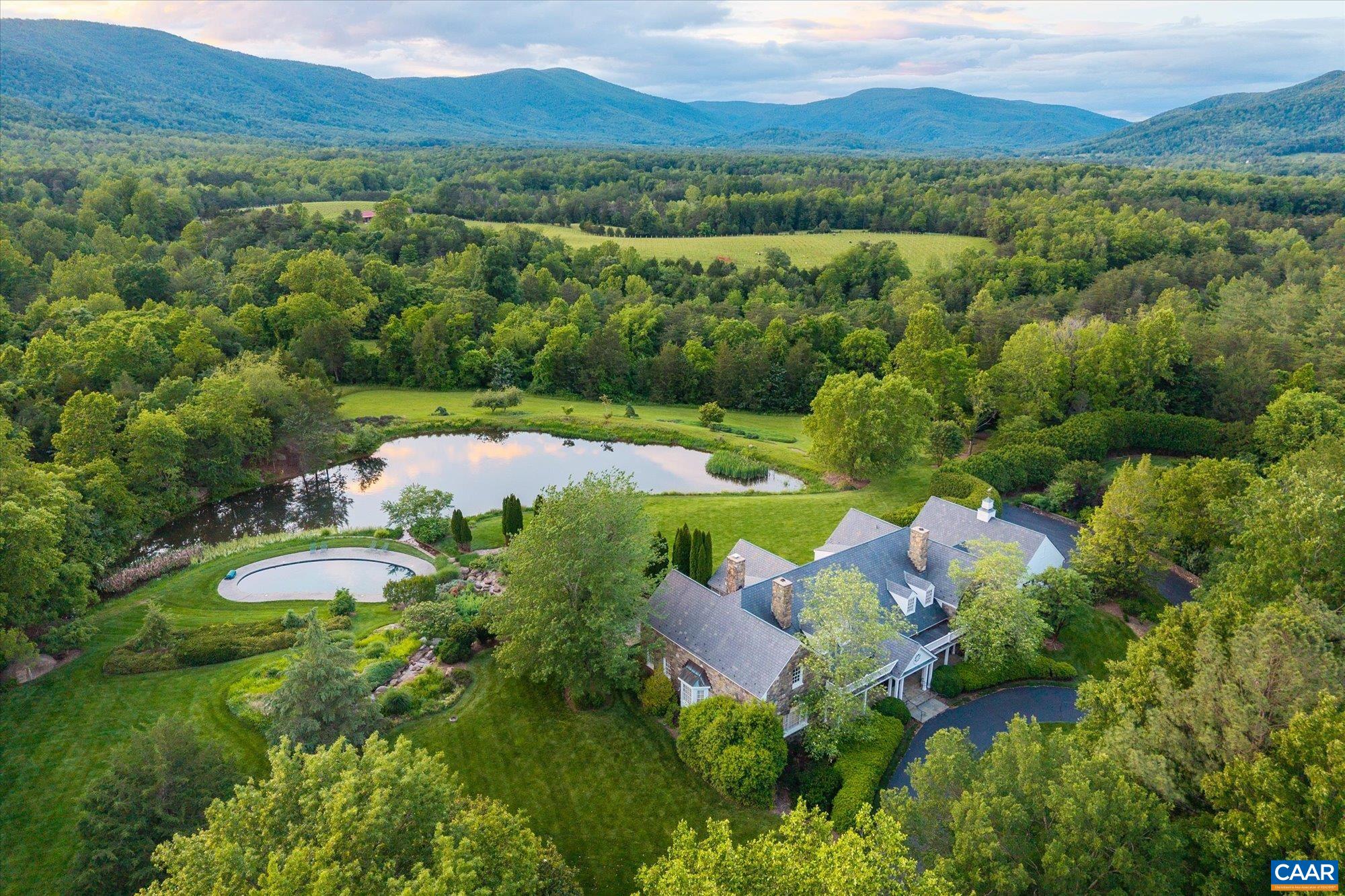 Situated at the foothills of the Blue Ridge Mountains, White Hall Estate  offers a rare blend of natural beauty, viticultural pedigree, and architectural distinction - just 14± miles from the City of Charlottesville. Spanning 212± acres with approximately 48 acres of established estate vineyards within the acclaimed Monticello AVA - recently named the top wine region in the U.S. - this turnkey winery and farm offers  both lifestyle enjoyment & production success. The stone manor home, custom built in 1992, with 5 bedrooms and 4.5 baths, is on a gentle rise, framing absolutely breathtaking panoramic views of the Blue Ridge Mountains & Shenandoah National Park. The over 12,600 sq.ft. winery building is the perfect flex space for a variety of pursuits and is equipped for not only production but also for events. The property also includes a tenant home and numerous outbuildings. A haven for wine enthusiasts, investors, and those seeking an elegant rural retreat, the property combines elevated terroir, proven varietals, and timeless design in a setting of serene grandeur. Whether as a private estate, boutique label, or hospitality venture, White Hall Estate is a legacy opportunity in the heart of Virginia wine country.
