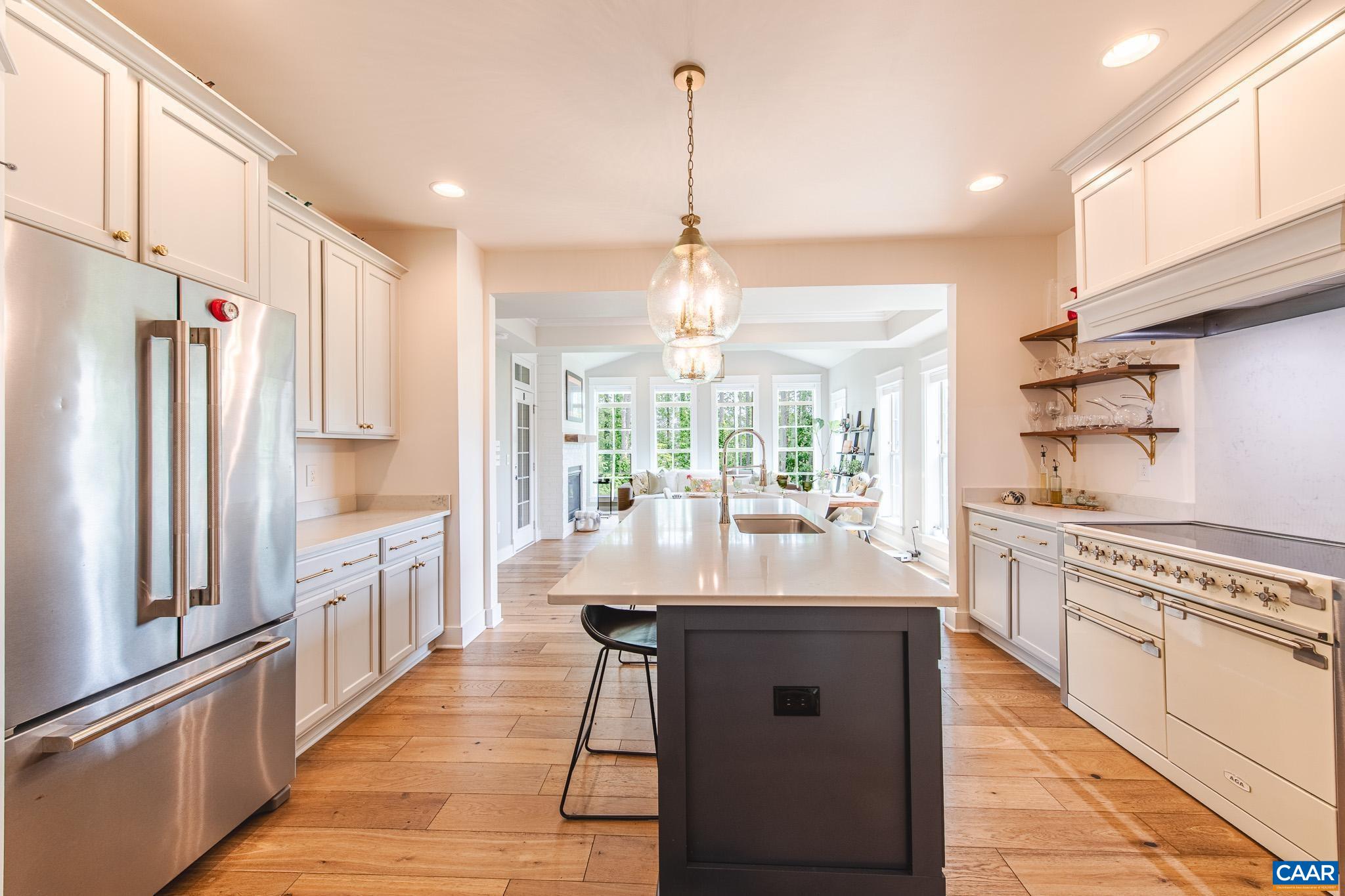 Discover this nearly-new, luxury home built in 2022 by Craig Builders, offering top-tier finishes and custom upgrades. Boasting an open floor plan, wide hardwoods, and two offices, the stunning kitchen features quartz counters, a 48" AGA induction range, and custom hood, flowing into a bright great room with cathedral ceilings and protected woods views. The owner's suite includes a spa-like bath with Carrera marble and towel warmer. Upstairs are a spacious loft, two bedrooms, and ample storage. The finished terrace level offers a versatile great room, a guest suite, and a shaded patio—perfect for entertaining. The whole-house generator leaves you protected from outages too! Located in Old Trail, walking distance to shops, dining, trails, and just a short drive to wineries and breweries. An ideal move-in ready home for the discerning buyer seeking elegance, comfort, and location.
