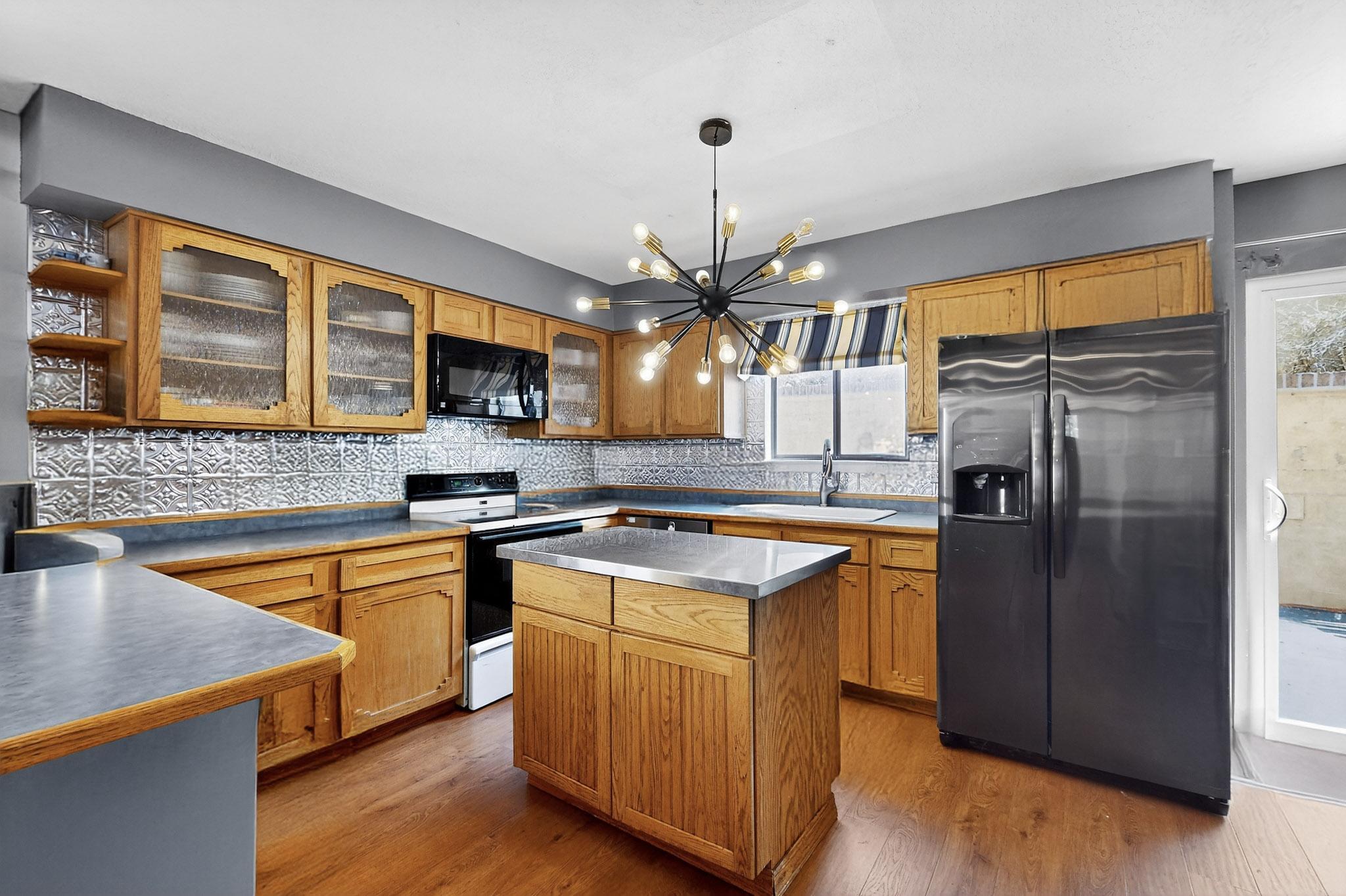 Nestled in tall pines, this split level home feels like its removed from the city, yet its close to everything you might need. Creative touches start with a painted walkway and murals on the backyard wall. Newer fans, flooring, sliding glass door, dishwasher, hot water heater, and some light fixtures. Two living spaces are great for entertaining, and the 2nd floor living room has a fireplace for cozy evenings. 1 bedrooms on the bottom floor and 2 on the top floor create space.The area is its own cute street close to a nice park, grocery stores, golf course, restaurants, and more. Come check this cutie out today!