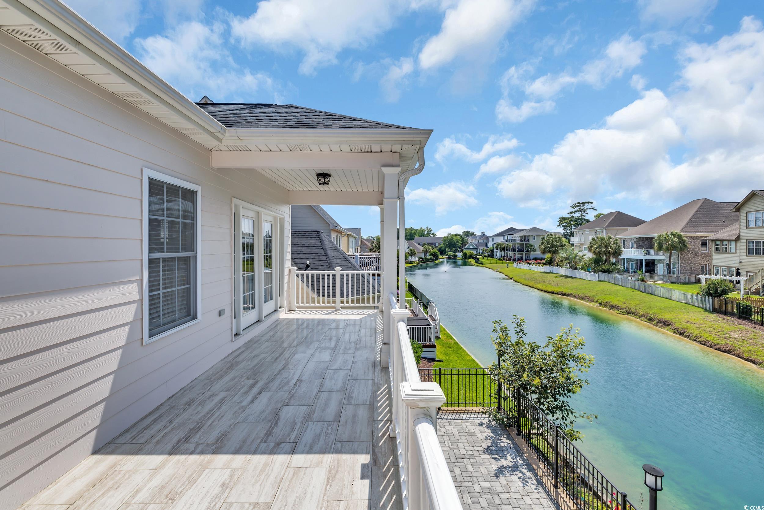 Wooden terrace featuring a water view and a residential view