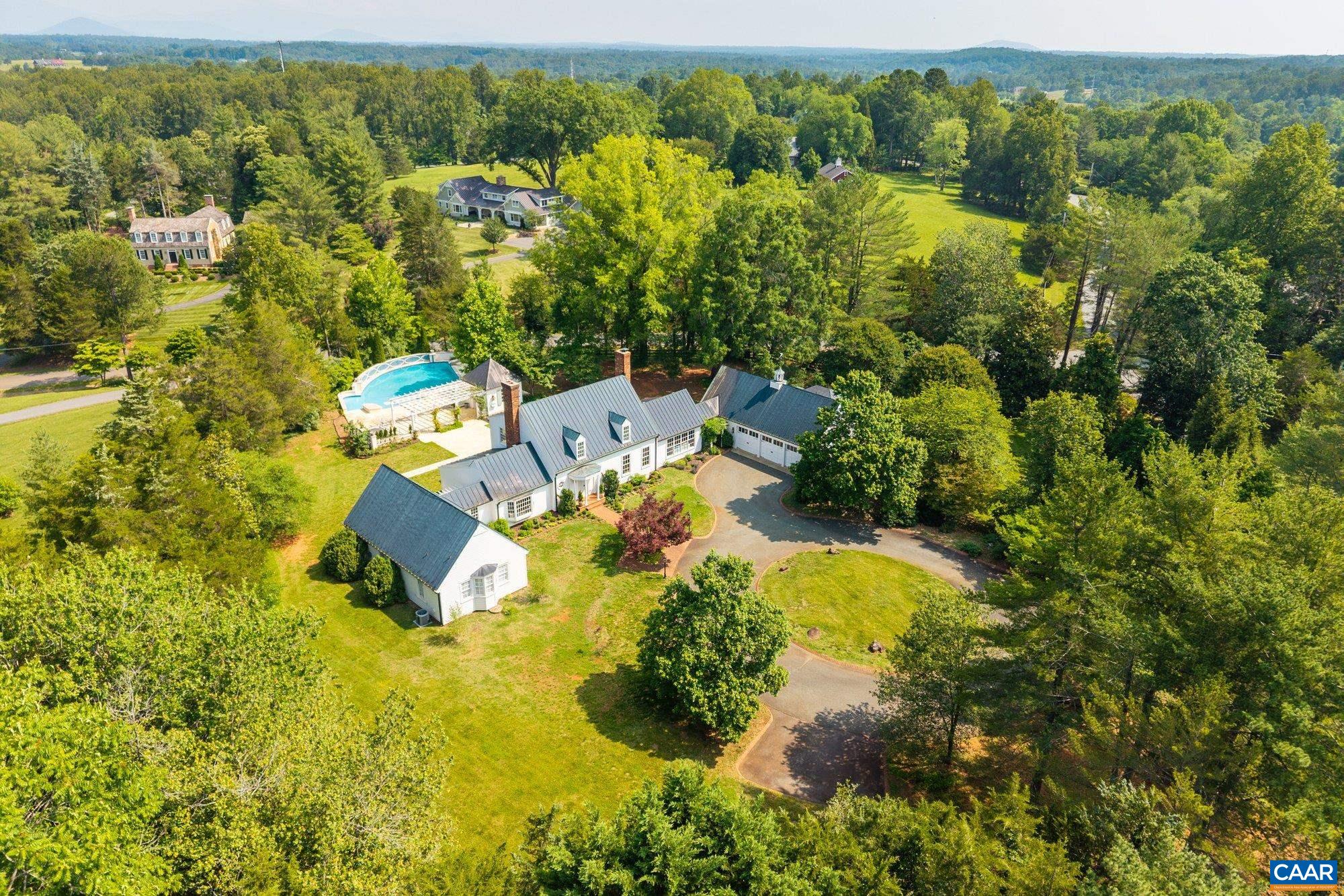 Perfectly positioned on a coveted 2.15-acre corner lot in the heart of Colthurst, 100 Tally Ho Drive is a masterfully reimagined Cape Cod offering over 6,700 square feet of refined living. Almost every inch of this four-bedroom, five-bathroom residence has been thoughtfully renovated with an uncompromising eye for quality, blending classic architectural elegance with modern luxury.  Inside, expansive yet intimate living spaces flow seamlessly—ideal for both grand-scale entertaining and everyday comfort. The layout balances form and function, featuring beautifully appointed formal rooms alongside inviting informal spaces, all bathed in natural light and framed by serene views of the surrounding grounds.  At the heart of the home lies a chef’s kitchen outfitted with top-tier finishes, opening to gracious gathering spaces and the outdoor terrace. An inviting pool anchors the expansive rear lawn, creating the ultimate outdoor retreat just minutes from UVA, Farmington Country Club, and the best of Charlottesville.  With its commanding presence, quiet setting, and comprehensive renovation, this is a rare opportunity to own one of Colthurst’s most distinguished homes.