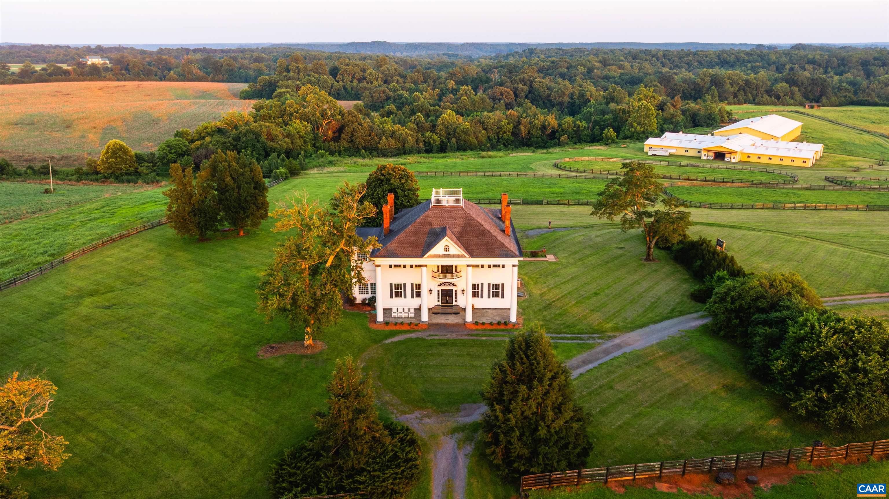 Greenfields Farm spans 753 acres just outside historic Scottsville, VA. A rare blend of rolling pasture, mature timber, and rich history, the property features a 1904 Colonial Revival main house with original architectural detail, a grand spiral staircase, arched transoms, and sweeping views from the widow’s walk. The residence offers copious amounts of living space, with three separate apartments and a caretaker’s home providing options for guests, staff, or extended family. Formerly a working horse farm, Greenfields includes fenced paddocks, a spring-fed creek, a stocked pond, a lake, and five wells. Equestrian facilities include a stable with 48 stalls, an indoor arena, a tack room, foaling stalls, grooming bays, hay storage, offices, and wash bays. Additional improvements include two equipment barns, grain silo, dog kennels, riding trails, and four gated entrances. With ties to Governor Wilson Cary Nicholas and Lady Astor, Greenfields is a legacy estate of rare scale and beauty.