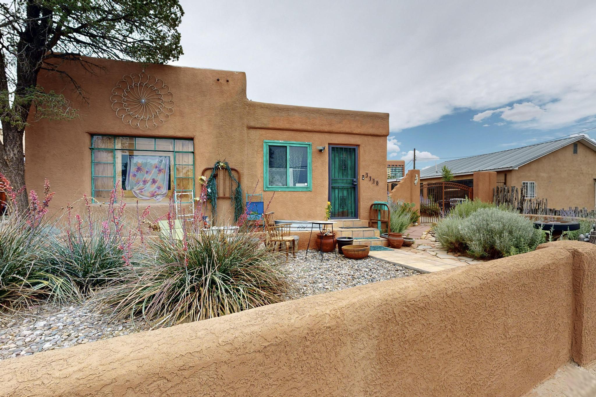 In the beating heart of Albuquerque's beloved Martineztown is this unique artistic adobe home steeped in history.For decades, one of the homeowners viewed the home as her creative canvas, with hand-painted splashes of color and uniquely vibrant touches throughout. From every corner of the home, you'll notice hand-carved doors, warm wood flooring, Saltillo tiles, thick walls, tin ceilings, and southwestern motifs.Zoned for commercial or residential use, this home can fit your visions and dreams for decades to come. This is truly a unique opportunity to carry on the legacy of generations past, to bring the home into the next generation, and to be a part of the story of Martineztown.
