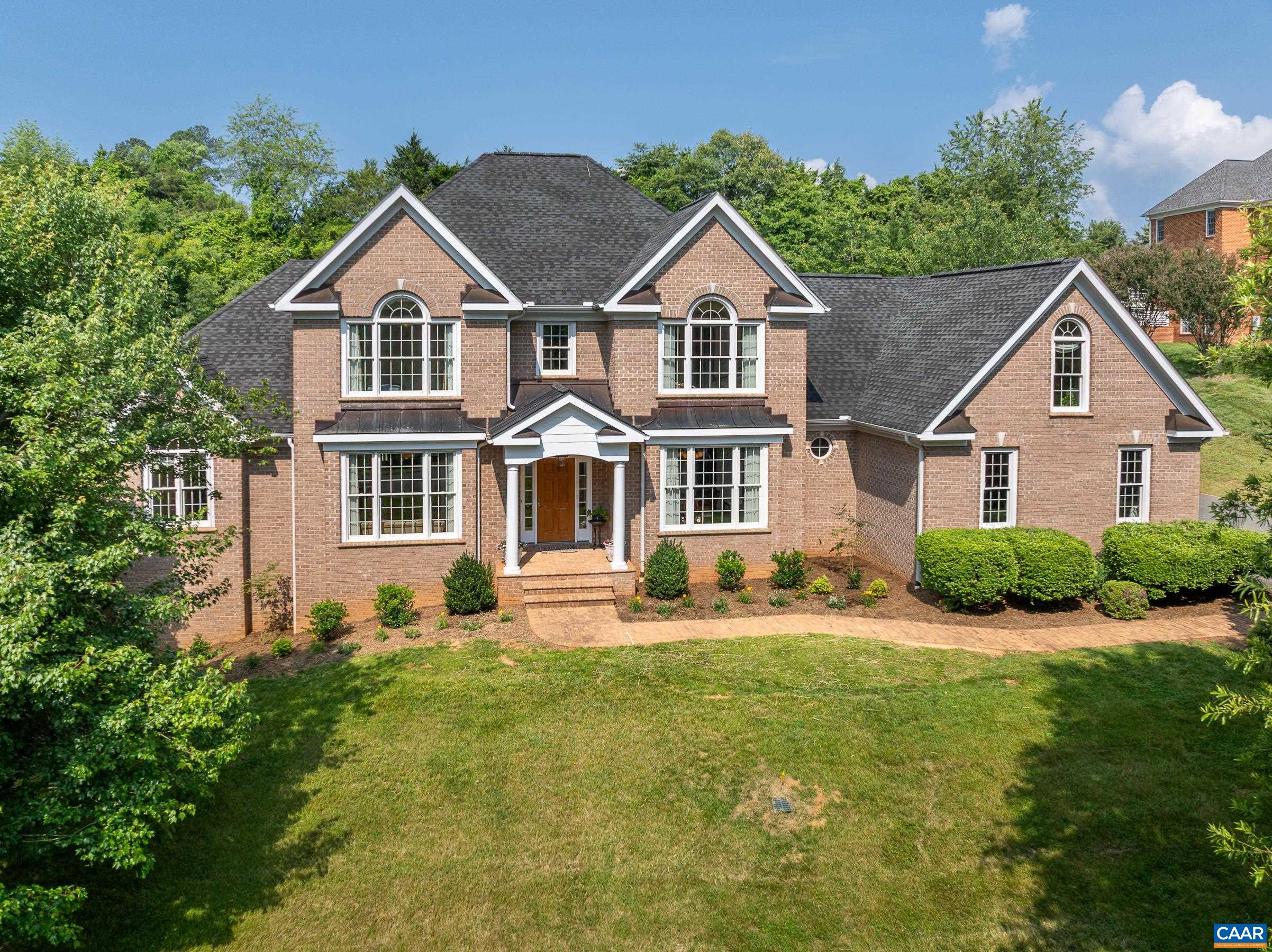 Exquisite Four-Sided Brick Home in Premier Established Community.  Great location just 10 minutes from UVA and Hospitals, with easy access to I 64, wineries, and breweries. This custom home features main and second level primary suites, hardwood floors throughout the upper levels, and a fully finished walk-out basement with LVP flooring! The open main level is an entertainer's dream with a two story great room featuring a gas fireplace with built-ins , a gourmet kitchen with all new stainless steel appliances, cherry cabinets and granite, large formal living and dining rooms and a cozy breakfast nook. For flexible living this home boasts a primary bedroom suite on all three levels! The main level primary suite includes a gas fireplace flanked by built in book shelves. If you'd prefer your owner's suite upstairs, there is a cozy suite with a light filled bathroom with jetted tub and shower.  Three additional bedrooms on the upper level share two full bathrooms.  The finished walk out terrace level includes a large rec room, a bedroom with ensuite and gas fireplace and extra bedroom/home office - great for guests.  3 car garage, & new landscaped yard.