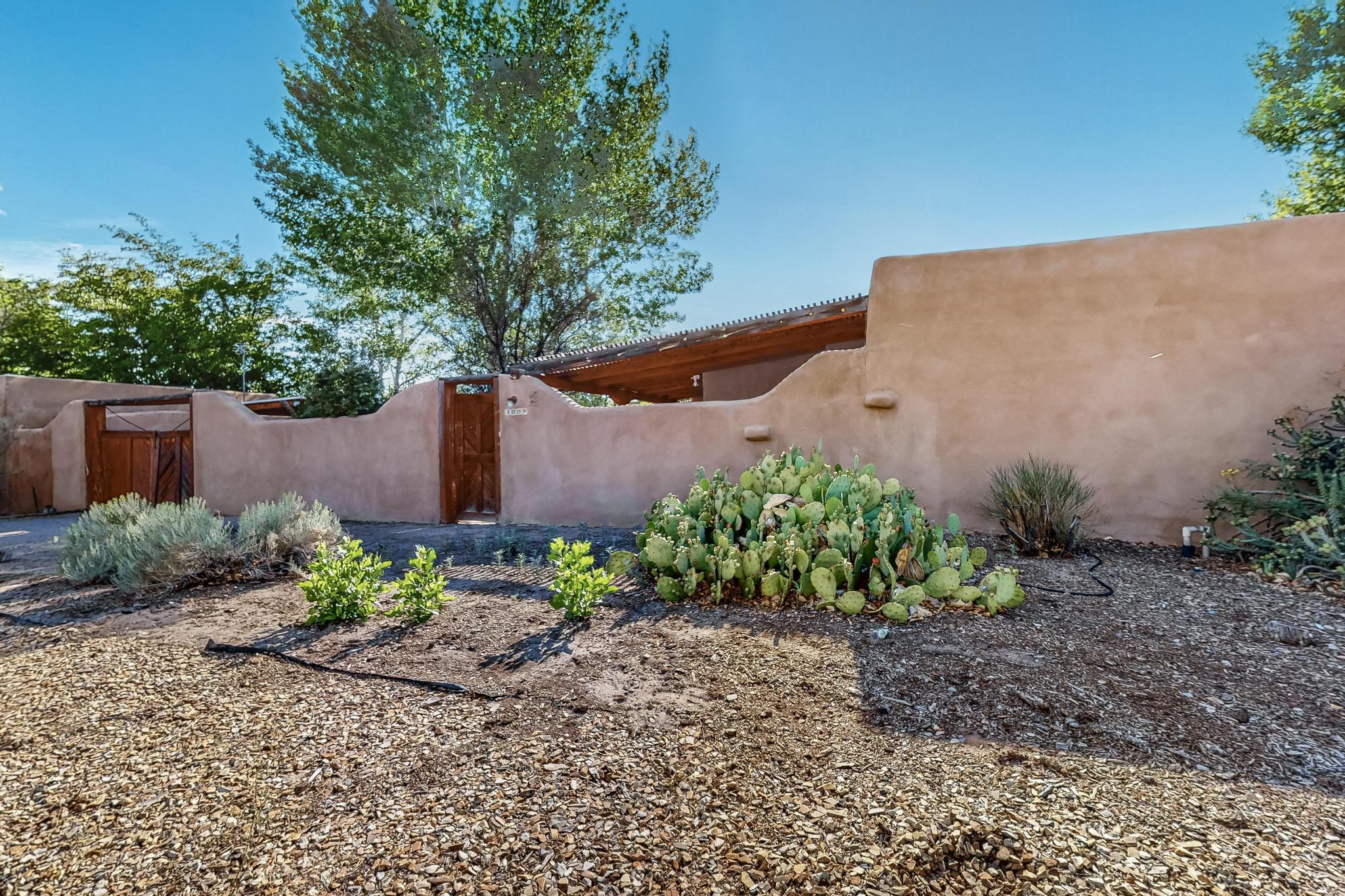 Hap Crawford was the famous architect/builder of this secluded North Valley home near Rio Grande NW. Private tall, walled courtyard with mature landscaping. Adobe home with mostly brick floors. Perfect floor plan. Fabulous vigas throughout. SW wood-burning kiva fireplace. Big master bedroom opens to courtyard. Beautifully carved front door. Lots of natural light from big windows and skylights. Radiant floor heating. Timeless charm, comfort, conveniences and poetry of the Valley. Desirable location North of Old Town on quiet, close-ended street. Close to restaurants, shopping, wineries, central ABQ, freeway access and Indian Cultural Center.