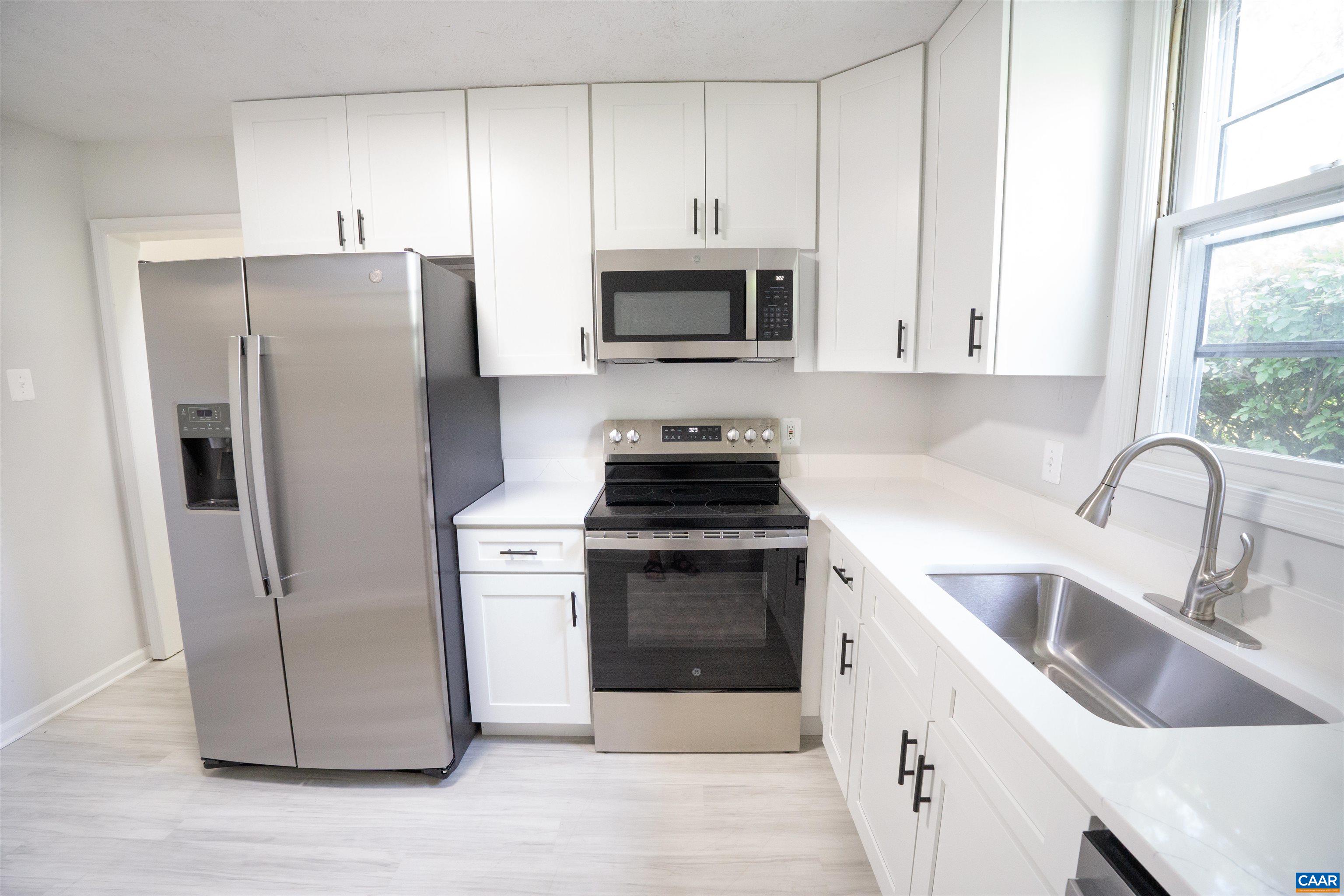 Welcome to Sherwood Manor! This spacious 3-bedroom, 2.5-bathroom townhouse offers an abundance of natural light and versatile living spaces. Recently renovated including luxury vinyl plank (LVP) flooring, new carpeting, and a fully updated kitchen with brand-new appliances including Washer and Dryer,  installed 2025! Upstairs, you'll find a primary suite, two additional bedrooms, and a shared full bathroom. Step out from the living room onto a private deck overlooking serene wooded views and expansive green space - perfect for relaxing or entertaining. Enjoy the ease of maintenance-free living, with exterior upkeep and lawn care included in the HOA. Located just minutes from I-64, 5th Street Station, and downtown Charlottesville, this home blends comfort, convenience, and style in a prime location.