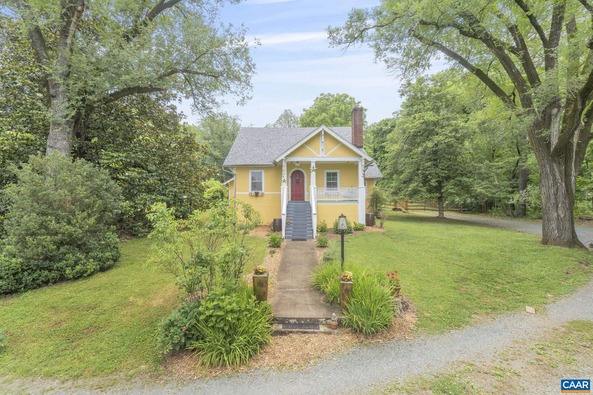Nestled at the end of a winding lane among stately trees and flowered fields, this 1930’s craftsman-style cottage balances architectural character and modern conveniences with storybook charm, the result being living spaces as magical as they are comfortable and welcoming. Solidly built and lovingly cared for, the home features a deep front porch, original hardwood floors, a light-filled modern kitchen, and an expansive sunroom with radiant floor heating and one of two Jotul stoves.  Additionally, the entry level offers a large bedroom, full bath, family room and dining room as well as a home office and a covered rear porch.  Accenting and delighting these spaces are stained-glass windows, glass knobs, built-in bookshelves, original moldings, and arched doorways.  Up the staircase are two additional bedrooms that include a Jack and Jill bath while in the basement one finds ample room for storage or future expansion plus a German propane furnace (2021) that heats through the home’s restored radiators. Outside, the elevated 4.3 acre lot features extensive walking trails, a generous 1 acre fenced area for pets or play,  a sizable storage building, formerly a garage, and a garden shed, all a mere five-minute drive to Pantops.