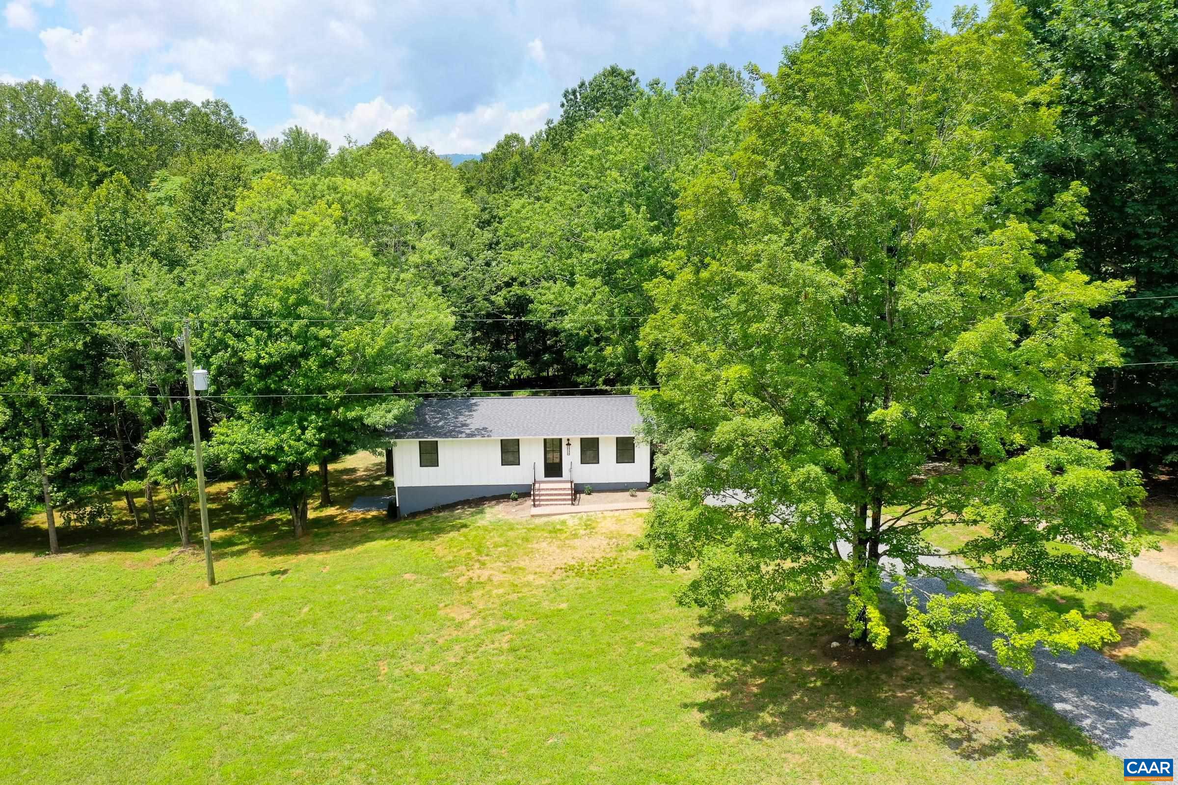 Charming western Albemarle Afton Cottage sits on 2 acres of private land and is completely renovated and updated inside and out! This board and batten farmhouse bungalow has been renovated from top to bottom. Stripped to the framing, this home features new roof, new windows, new drywall, refinished hardwood floors, new LVP flooring, newly finished basement doubling the finished living space and square footage, all new bathrooms, kitchen, electrical and plumbing. It even includes a new well and inspected and pumped septic system for total peace of mind! You'll love the refinished hardwood floors in the living/dining room and modern white kitchen with new stainless appliances, granite counters and beautiful large island.  Three bedrooms share an elegant new full bathroom on the main level.  New tile floors, walk in shower with frameless glass, vanity and lighting.  The newly finished basement features LVP flooring in a large rec room, a fourth bedroom, a full bathroom with double sink vanity, tub/shower combo, new lighting and fixtures.  This secluded retreat is minutes from 151 wineries and breweries at the base of the Blue Ridge Mountains.  Don't miss it!