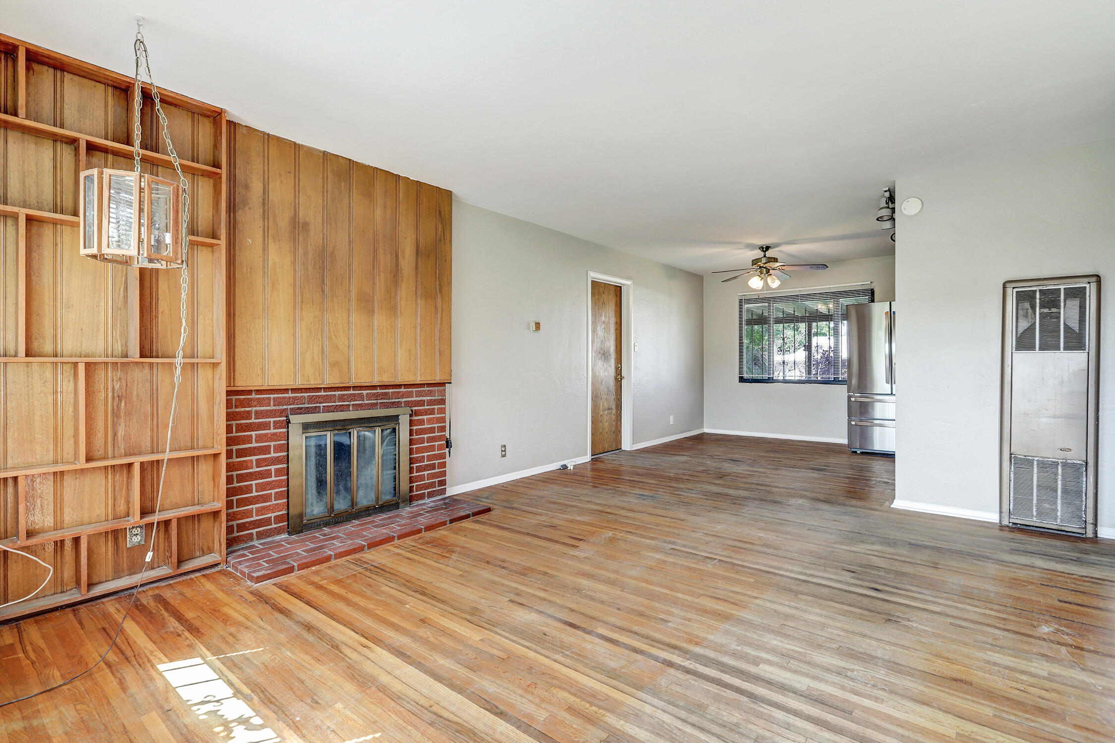 Step into this charming, classic Mossman home featuring its original brick fireplace and beautiful oak flooring throughout. Located in the highly sought-after Uptown neighborhood, you're just moments away from shops, restaurants, and local amenities. The open-concept living area offers a bright, inviting space with unique architectural details that add warmth and character. Both the front and back yards boast mature landscaping, including fruit trees and blooming roses. Notable updates include a new electric panel, sewer line and wall heater replacement (2022), a newer roof (2017), and a swamp cooler installed in 2018.