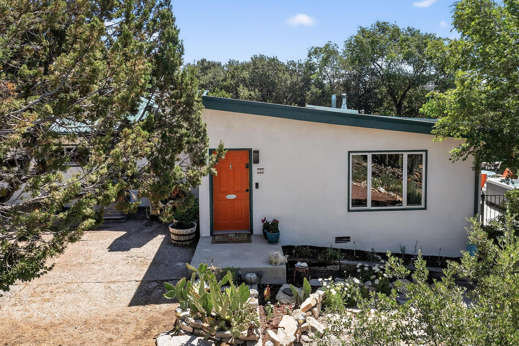 This beautifully updated home blends warm artistic charm with breathtaking vistas. Thoughtful updates throughout include refreshed kitchen and baths, HVAC, and more. The spacious great room and adjoining deck are perfect for gatherings and for soaking in the sweeping mountain views. Enjoy landscaped paths with cozy sitting areas and gardens. A fully heated/cooled two-story artist studio (approx. 796 SF,  with 3 mini splits) is included in the overall square footage. and future use potential for this space is huge! The new oversized 4-car metal garage with two large roll-up doors is a dream for rural living. A peaceful oasis just minutes from Albuquerque, this one is a must see!
