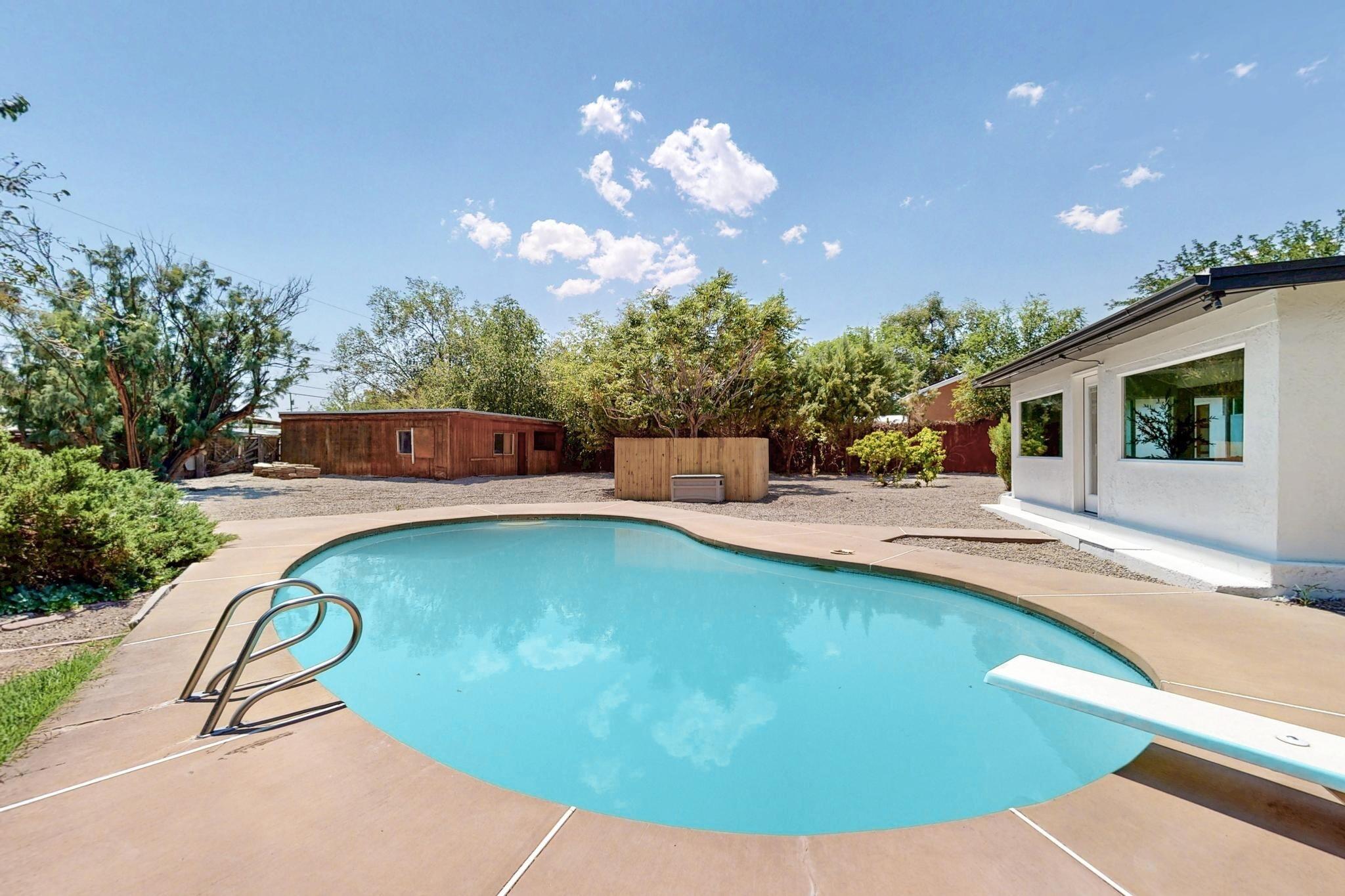**Seller offering $5,000 for Rate Buy Down with accepetable offer** Completely remodeled Los Ranchos gem on a private 1/2-acre cul-de-sac lot! This home features brand new thermal double-pane windows, fresh interior/exterior paint, new laminate & carpet flooring, updated fixtures, and LED lighting throughout. Two spacious living areas and a large open kitchen with satin granite countertops, farmhouse sink, and new stainless appliances. Two fireplaces (wood-burning & electric), 3 bedrooms, 3 baths--including two stunning remodeled bathrooms and a half bath in the service room. Walk-in closet, skylights, 8' ceilings, refrigerated air, 2 A/C units, pool with diving board, lush landscaping, barn/workshop, side yard access, and oversized garage.