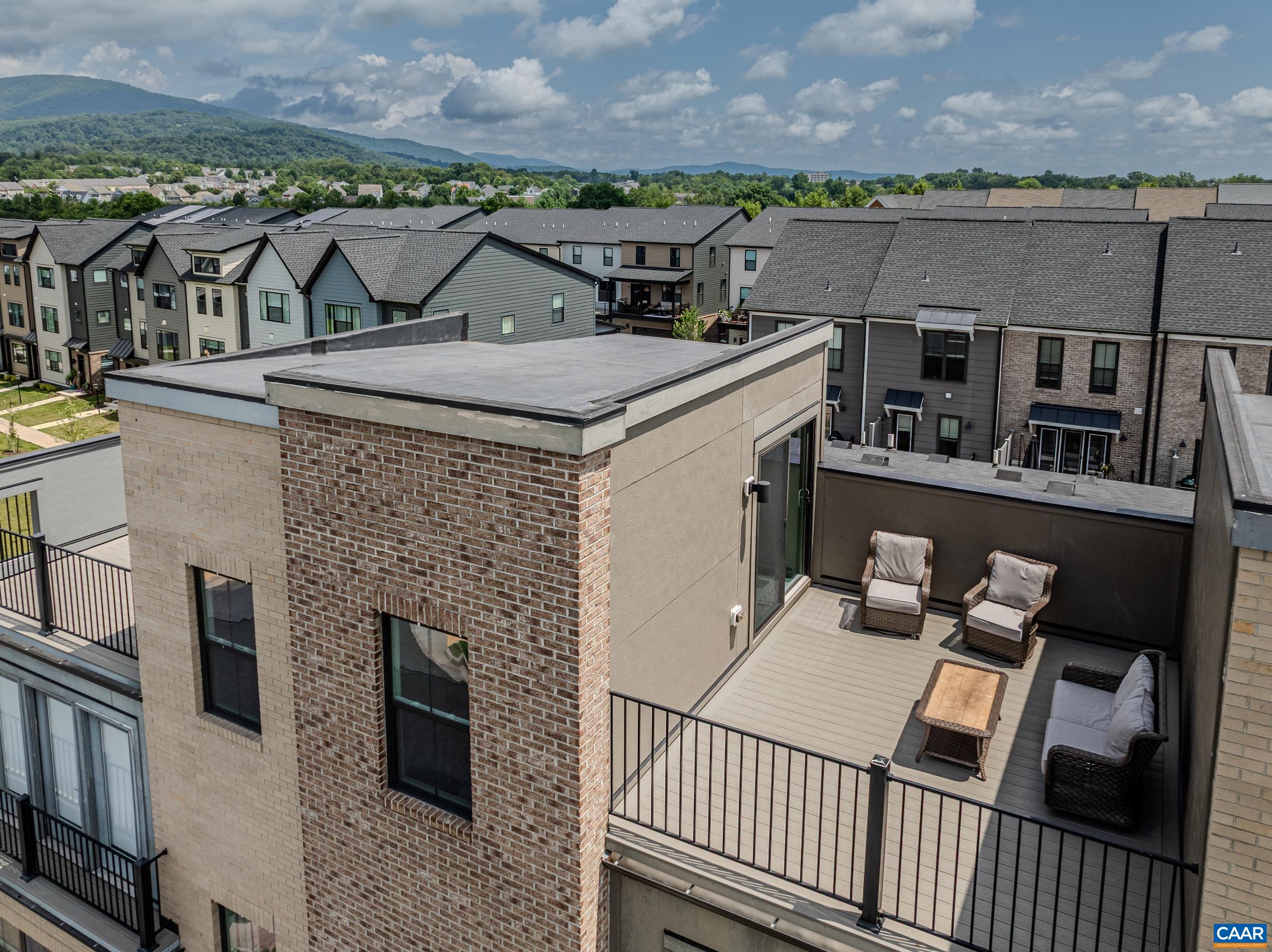 New PRICE!!  Great value in Old Trail!  No construction around you.  Discover an extraordinary Eco-Friendly living experience. This four-story townhome combines modern design with mountain vistas walkable to the Town Center. The heart of the home is an open-concept living area with luxury vinyl plank flooring and a modern kitchen that boasts hardwood cabinetry, granite countertops and stainless appliances - perfect for both everyday living and entertaining. The home's thoughtful layout maximizes both comfort and functionality. The bedroom level showcases a generously sized owner's suite with a private bathroom with two sink areas and a sleek, frameless-glass shower. A second primary suite features an ensuite bathroom with tub/shower combo, and a full sized laundry room features a full-sized Maytag Washer and Dryer. The ground floor offers versatility with a third bedroom/home office with full bathroom, and mudroom. Perhaps the true gem of this property is the spectacular rooftop terrace—an urban oasis that will become your favorite retreat. Practicality meets luxury with a one-and-a-half-car rear-entry garage and a wide rear deck for al fresco dining.