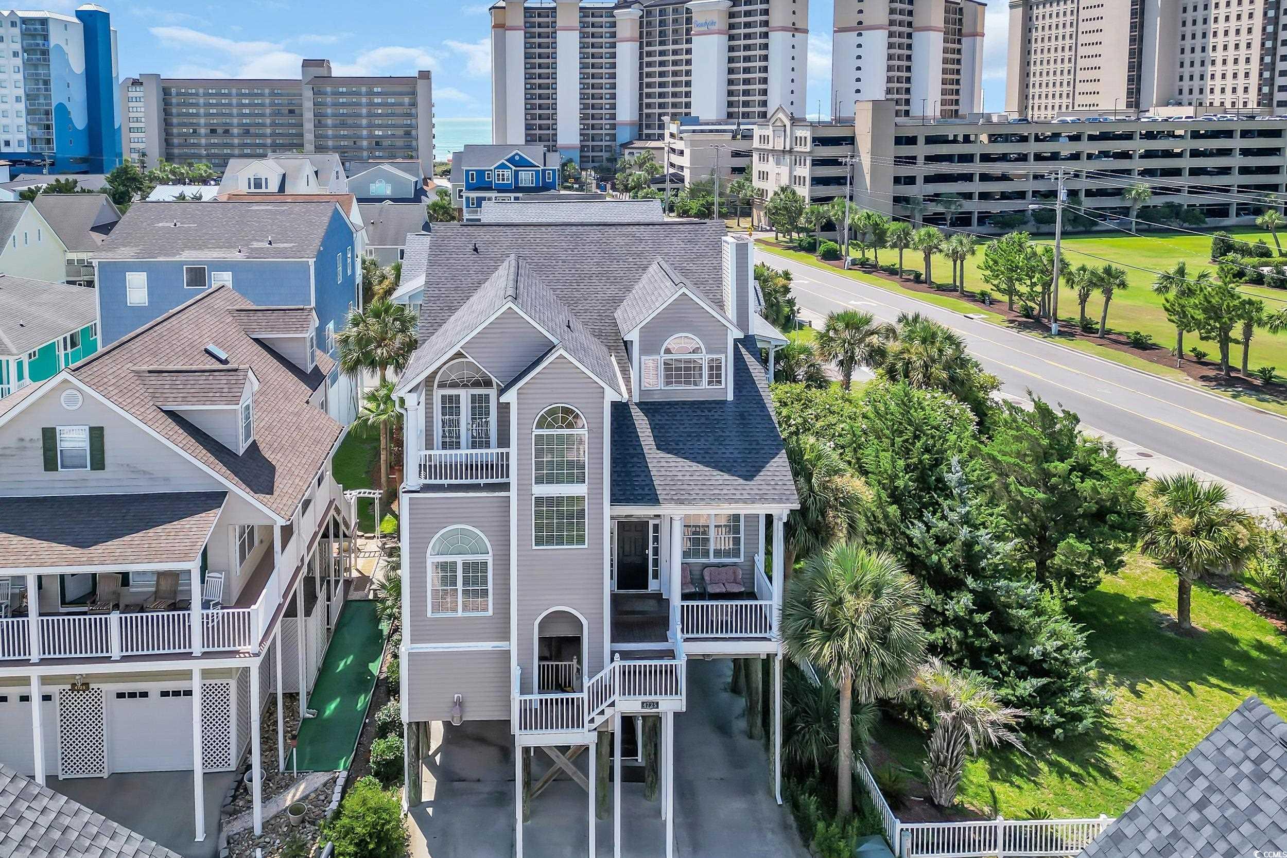 Welcome to 4725 Harmony Lane, North Myrtle Beach – a spacious 4BR/4.5BA raised beach home located in the desirable Windy Hill section, just steps from the sand and directly across the street from North Beach Plantation! Enjoy peek-a-boo ocean views and cool coastal breezes from this well-appointed property, perfect as a full-time residence, vacation getaway, or income-producing rental.  This bright and inviting home features an open-concept living space with cathedral ceilings and an abundance of natural light. The spacious living room includes a cozy sitting area and a wet bar, ideal for entertaining. The large dining area flows seamlessly into a fully equipped kitchen, perfect for preparing meals or enjoying catered options from local eateries.  The primary suite is conveniently located on the main level, complete with a king bed, sitting area with sleeper sofa, a generous bathroom, and a jacuzzi tub. Upstairs, you'll find three additional bedrooms: two with queen beds (one with its own private balcony) and one with two twin beds—each with its own private bathroom. A half bath is also located on the main floor for guests.  This home offers flat-screen TVs in every bedroom, ceiling fans throughout, and beautiful ocean-facing windows that enhance the relaxed beach lifestyle. Outside, enjoy the raised beach-style construction, with space underneath for parking or potential outdoor living.  Located just minutes from Barefoot Landing, The House of Blues, Alabama Theatre, Alligator Adventure, Duplin Winery, and a wide variety of restaurants, shopping, and entertainment. This home also offers easy access to golf cart rentals, beach access, and other coastal conveniences.  Don't miss the opportunity to own this exceptional beach retreat in one of North Myrtle Beach’s most sought-after communities!