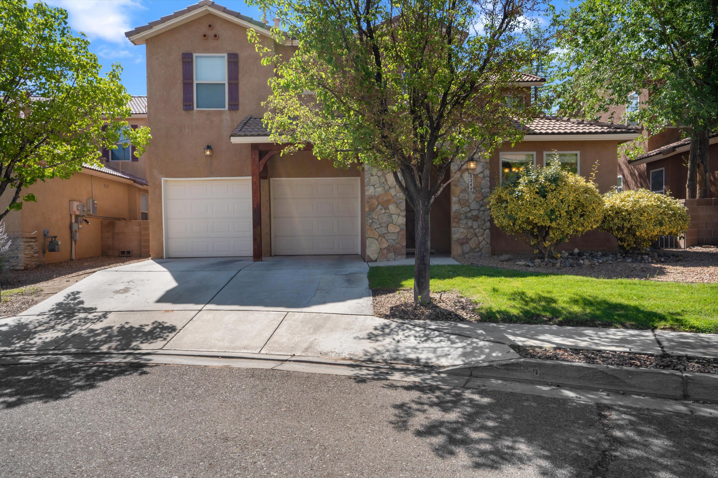 Step into elegance at this stunning Stillbrooke home in the sought-after Aldea at Santiago community in Bernalillo. Expertly crafted with striking stone accents and a classic Spanish tile roof, this residence exudes timeless charm. Enjoy modern comforts with refrigerated air, sleek granite countertops, premium upgraded cabinetry, and soaring high ceilings. The thoughtfully designed layout boasts two spacious living areas, a versatile office, and a cozy living room anchored by a shared fireplace. The main-floor primary suite is a true retreat, featuring a generous walk-in closet, dual vanities, and a luxurious garden tub. Outside, the expansive lot is beautifully xeriscaped with low-maintenance plantings, complemented by inviting stone seating and a charming fire pit.