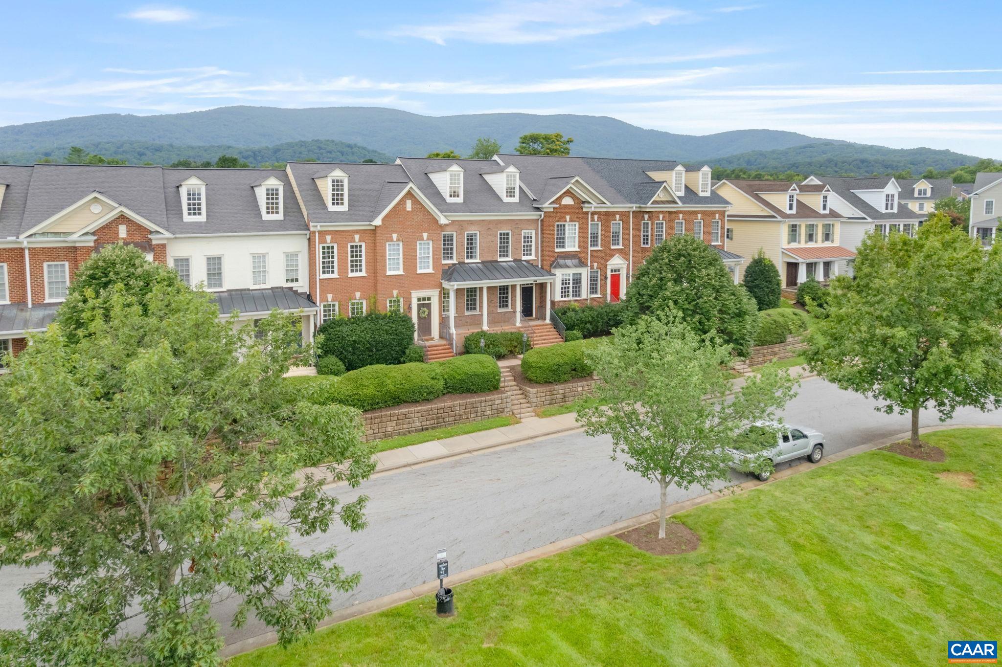 This two story 3BR, 2.5BA brick townhome overlooking Old Trail Commons has been well maintained and offers large 2 car detached garage with loads of storage. An easy walk to downtown Crozet(Library, Piedmont Place -restaurants, ice cream) and the Old Trail town center (Grit Coffee, ACAC fitness & restaurants). The flexible open living spaces on the main level feature cherry hardwoods throughout, an eat-in gourmet kitchen open to sunny family room plus separate living & dining rooms. Attractive & functional kitchen w/ cherry cabinets, granite counters, gas range, a built-in desk/workstation and an island with breakfast bar. Finishes include gas FP with stately mantle & stone surround, french doors to a rear courtyard, new carpet, new HVAC systems 2022.  Spacious owner's suite has a walk in closet, bathroom with two separate vanities, large tile surround corner soaking tub and separate shower. Two additional bedrooms share a hall bathroom with double vanity, and the laundry room is conveniently located on the 2nd level. Low-maintenance, fenced back yard features privacy fence, patio, HOA manages the landscaping.