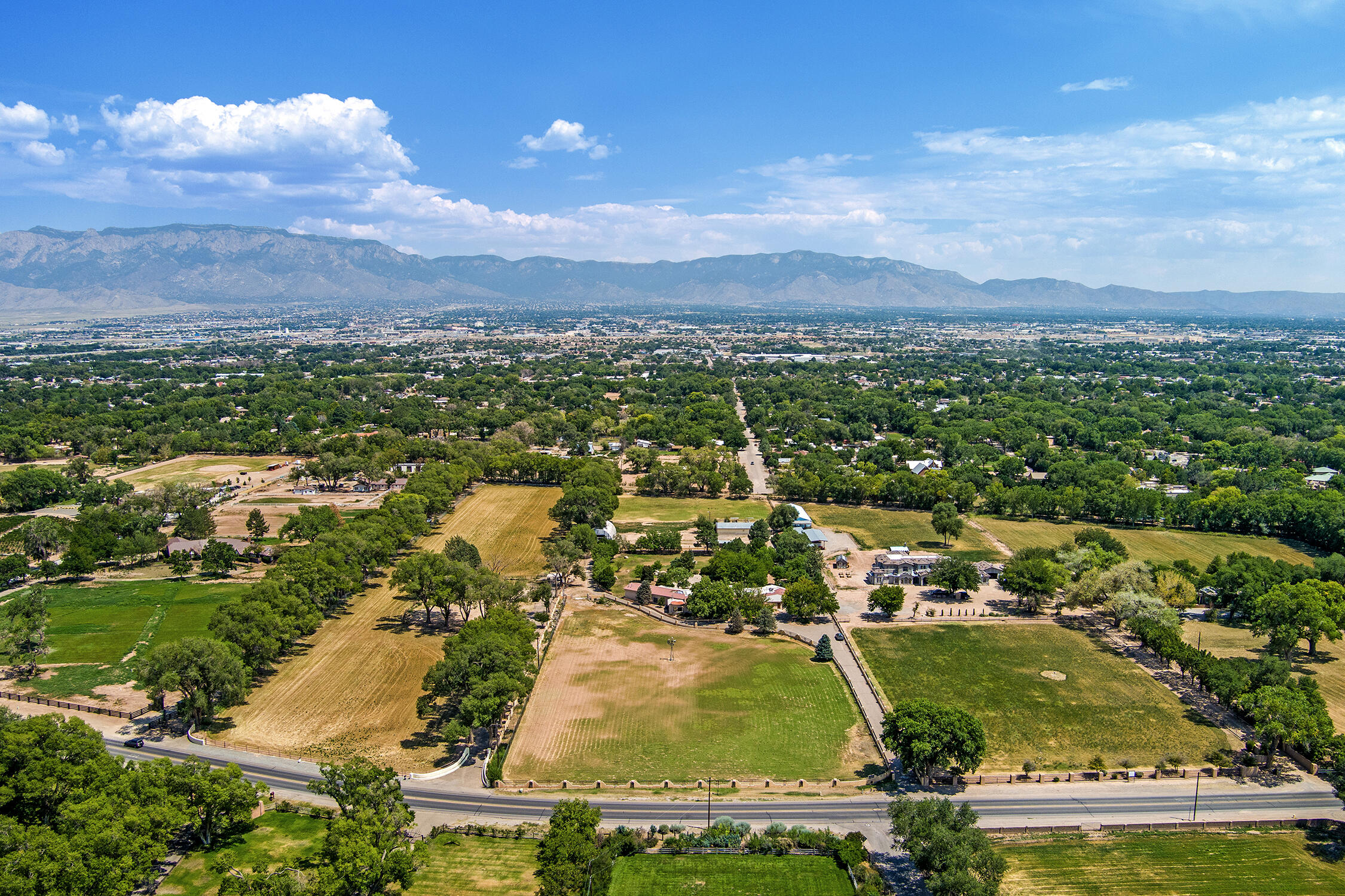 Spectacular home located in Los Ranchos de Albuquerque - Endless Possibilities. Discover this unique opportunity, plus its just a short drive to Santa Fe! Eight irrigated acres across two parcels (five acres and three acres). Broker research indicates potential for further subdivision, a rare offering among remaining large parcels in the area.The impressive ~7,957 sq ft home offers:Four bedrooms, five bathrooms Three spacious living areas Dedicated office, Attached three-car garage Detached 1,100 sq ft workshop/garage with room for 5+ carsEnjoy original quality craftsmanship and custom features throughout. With room for horses, agricultural uses, or development, this estate offers endless possibilities to create .