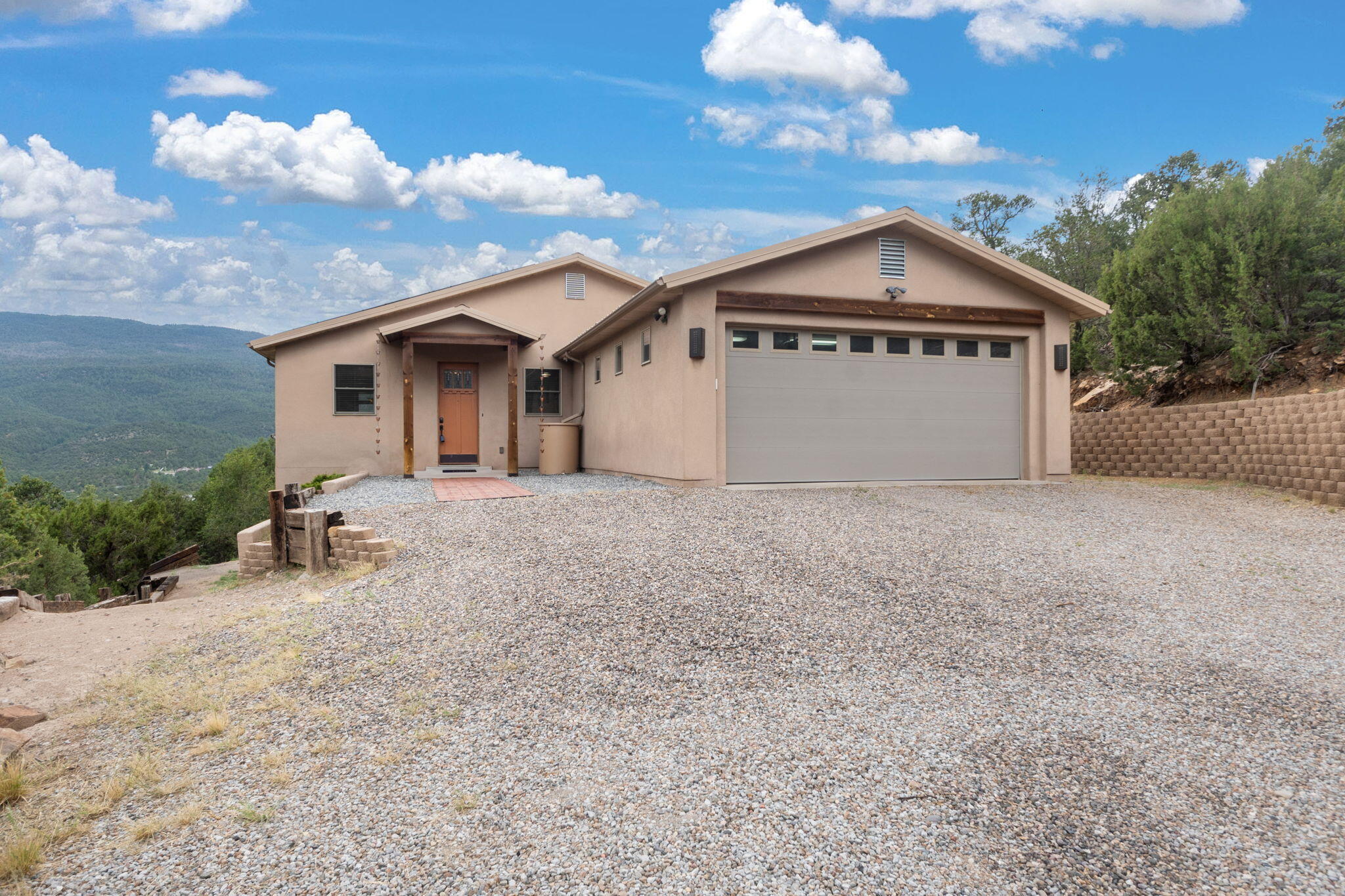 Peaceful mountain living with breathtaking Sandia views! This Cedar Crest retreat offers serenity, style, and connection to nature--just minutes from city conveniences. Enjoy sunsets from the spacious deck with hot tub. Inside, hickory-scraped engineered hardwood, tile floors, and Pella windows showcase quality throughout. Custom alder cabinets, granite counters, and updated baths add charm. Finished basement with wet bar and hobby room, solar panels, and UTV/workshop garage complete this gem.