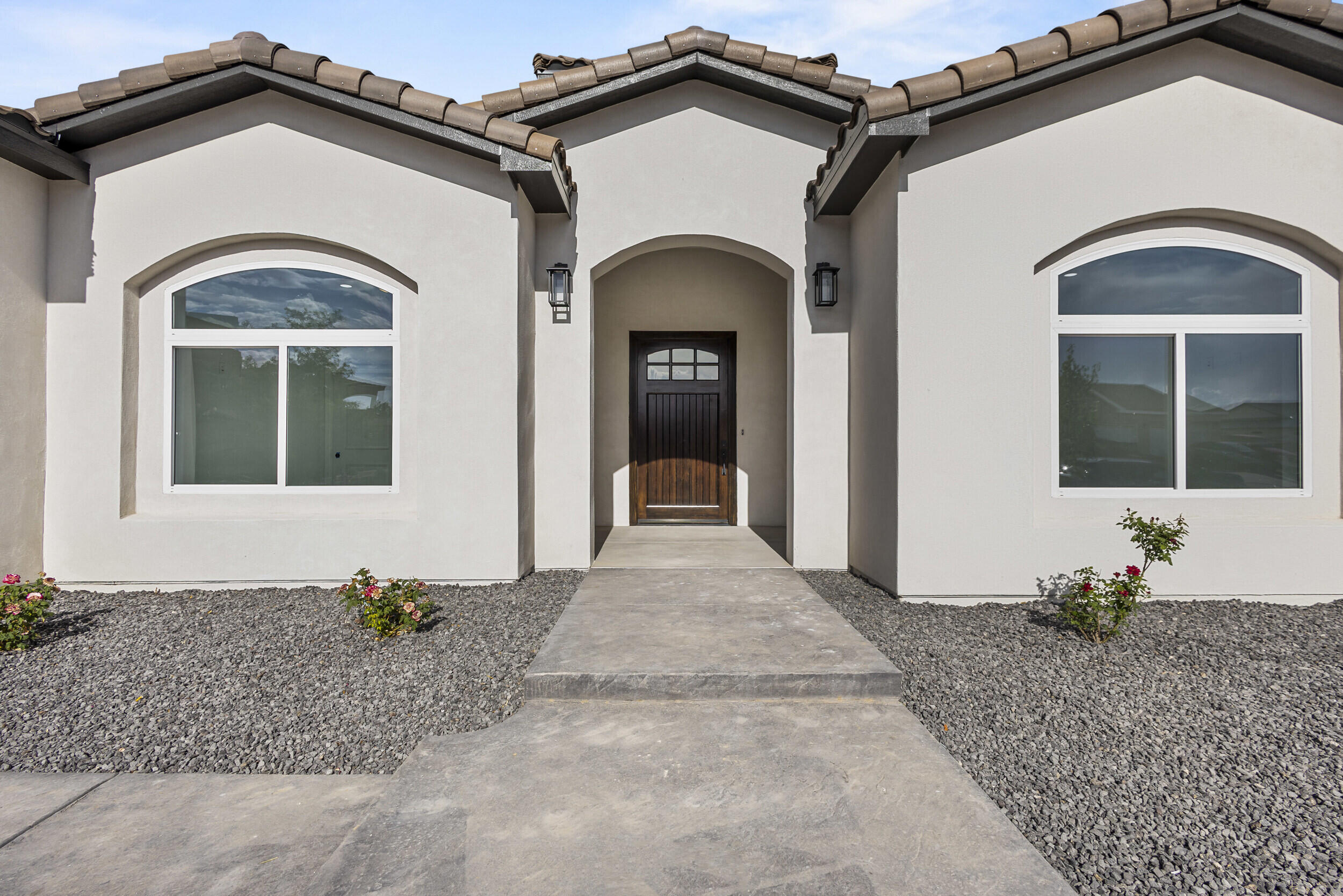 Stunning custom-built 4-bedroom (possible 5), 4-bath home boasting 3,670 sq ft of elegant living space. Features an oversized 3-car garage epoxy flooring, tile throughout, quartz countertops in the kitchen and baths, and stone tile fireplace. The chef's kitchen includes a quartz waterfall island, custom cabinetry, and a massive baker's pantry. Enjoy the cozy gas fireplace in the living room, balcony views with sliding glass doors, and a downstairs rec room with additional sliding access. Dual washer/dryer hookups and separate heating/cooling units for each floor offer maximum convenience. Fully landscaped front yard and back yard. Located minutes from the highway, dining, shopping, and Los Lunas High School.