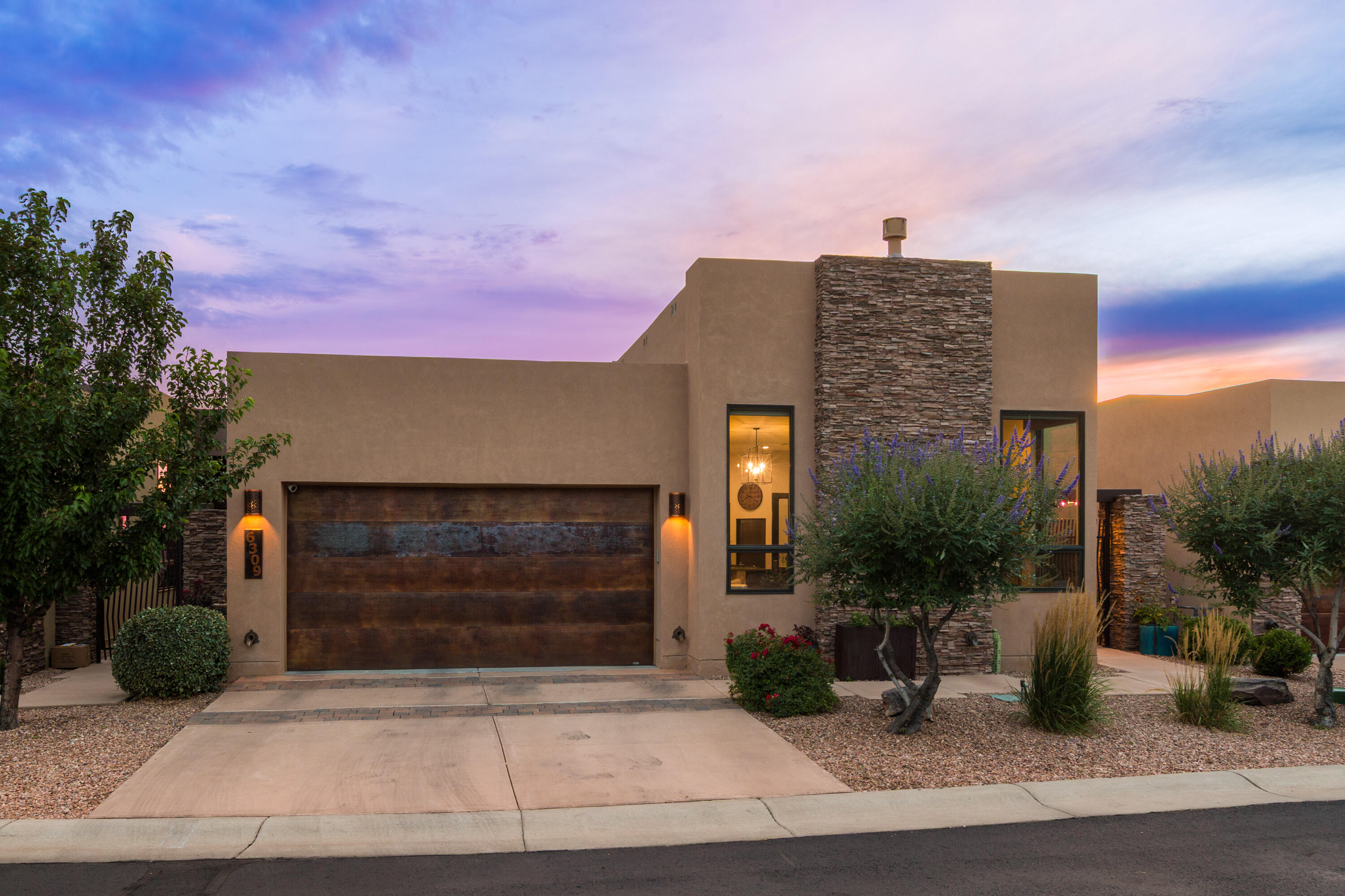 Experience modern luxury in The Legends, a prestigious gated community in Albuquerque's High Desert. Built by Las Ventanas Homes, this contemporary residence showcases sleek design, clean lines, and exceptional craftsmanship. Enjoy stunning Sandia Mountain views, energy efficiency with fully owned solar panels, and a versatile layout perfect for multigenerational living.  The entry way courtyard is private and cozy and the open-concept main level features a chef's kitchen, designer finishes and the primary bedroom on the main level. The walk-out basement includes private in-law quarters with a kitchenette and living area. With access to scenic trails, a private courtyard, and the serenity of the High Desert, this home offers the ultimate blend of style, sustainability, and functionality