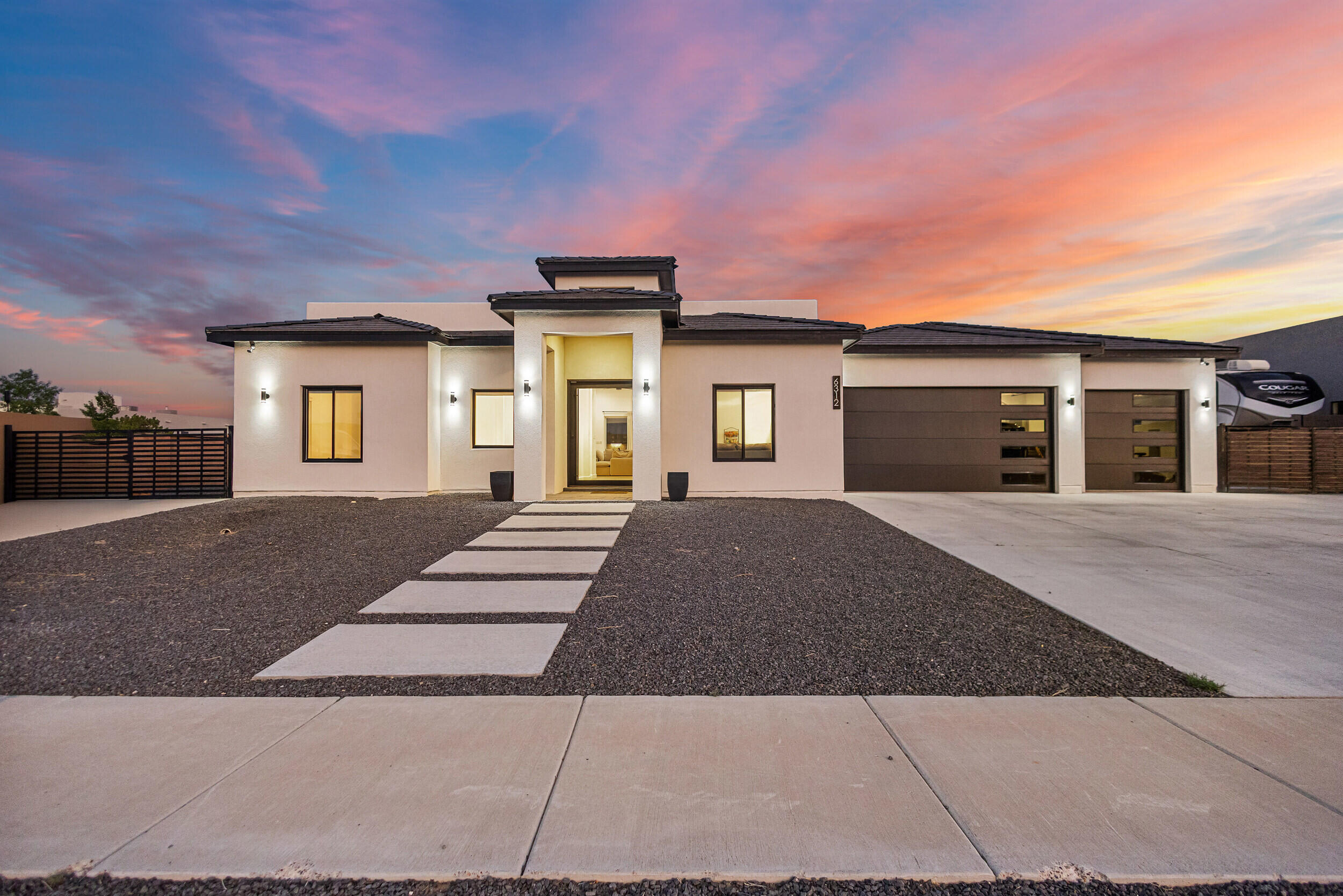 Welcome to 6312 Canavio Rd in the prestigious Petroglyph Estates. Surrounded by custom homes, this 3-bed, 3-bath residence offers 2,615 sq ft of heated living space (4,142 sq ft total). Enjoy a spacious floor plan featuring a private theater room, a chef's kitchen, and large windows with stunning Sandia Mountain views. Step outside to a custom outdoor kitchen--perfect for entertaining. Located near the Petroglyph National Monument, this home blends luxury, comfort, and the beauty of the Southwest. Roof is structurally engineered for a deck and backyard access is available on both sides.  One side of yard contains clean out, water hookup, electrical hookup for RV.  A rare opportunity in one of Albuquerque's most sought-after communities!