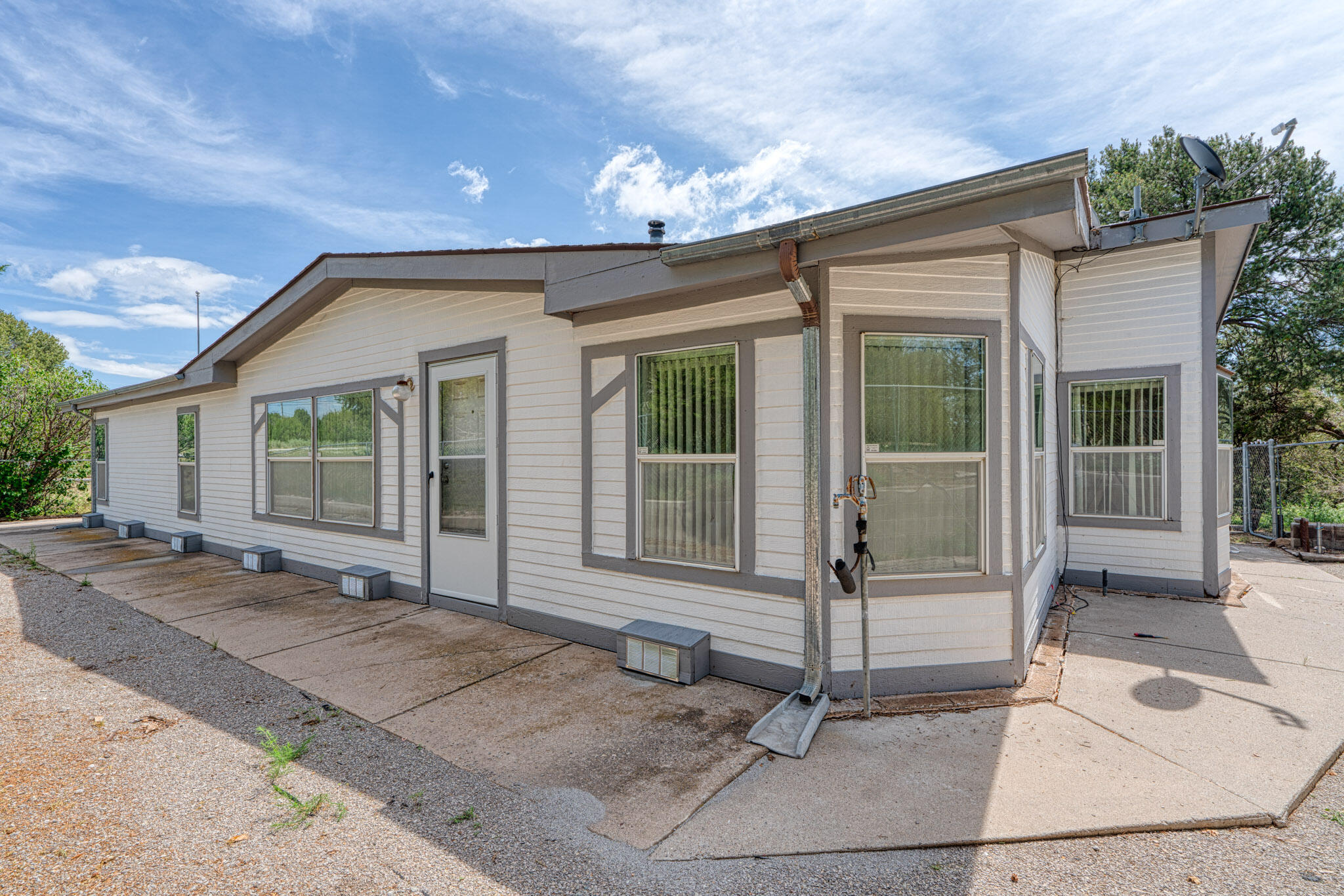 Location, Location, private wooded lot on Mountain Valley Road, 20 minutes to ABQ.This is an older but well built Schult home 2X6 construction, all factory tape and texture, new vinyl laminate floors, walk-in closets, pellet stove, lives large! Includes an oversized 28X28 detached 2 car garage with room for a 3rd car or workshop area, big beautiful covered patio with flagstone, 2 storage sheds,  mature landscaping, Community Water, come see it today!
