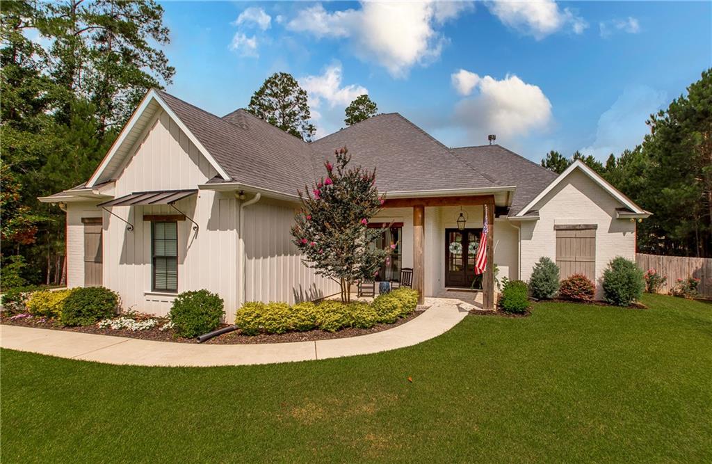 Welcome to this stunning 4-bedroom, 3-bath custom built farmhouse nestled in the prestigious Abita Lakes subdivision. Perfectly positioned on an oversized lot at the end of a quiet cul-de-sac, this exceptional home backs up to 160 acres of serene, protected preserve, offering ultimate privacy and breathtaking natural views.

Step inside to discover a thoughtfully designed open floor plan filled with high-end finishes and luxurious details throughout. The inviting living room features elegant coffered ceilings and a gas fireplace adorned with a beautifully crafted millwork mantle and custom built-ins for added charm and storage.

The chef’s kitchen is a dream come true, outfitted with top-of-the-line Commercial Kitchen Aid stainless steel appliances, sleek Quartz counter-tops, and a built-in banquette with custom cushions, both stylish and low-maintenance. Entertain with ease thanks to the wet bar, butler’s pantry, and designer lighting that adds a polished, upscale touch.

Retreat to the exquisite primary suite, where coffered ceilings elevate the space and a private breakfast wet bar brings added convenience. The spa-like ensuite features double Quartz vanities, a spacious walk-in shower, a relaxing soaking tub, and a large custom walk-in closet.

Beyond the bedrooms, this home offers two additional flex spaces, perfect for a home office or creative space, one located off the primary suite and the other near the kitchen. A custom mudroom adds both style and functionality to your everyday routine.

Three additional bedrooms are generously sized, providing comfort for family or guests. Step outside to a spacious, covered back patio and enjoy peaceful evenings surrounded by your own private green space and the beauty of nature beyond.

This one-of-a-kind home truly checks every box. Schedule your private showing today and experience the lifestyle you’ve been dreaming of.