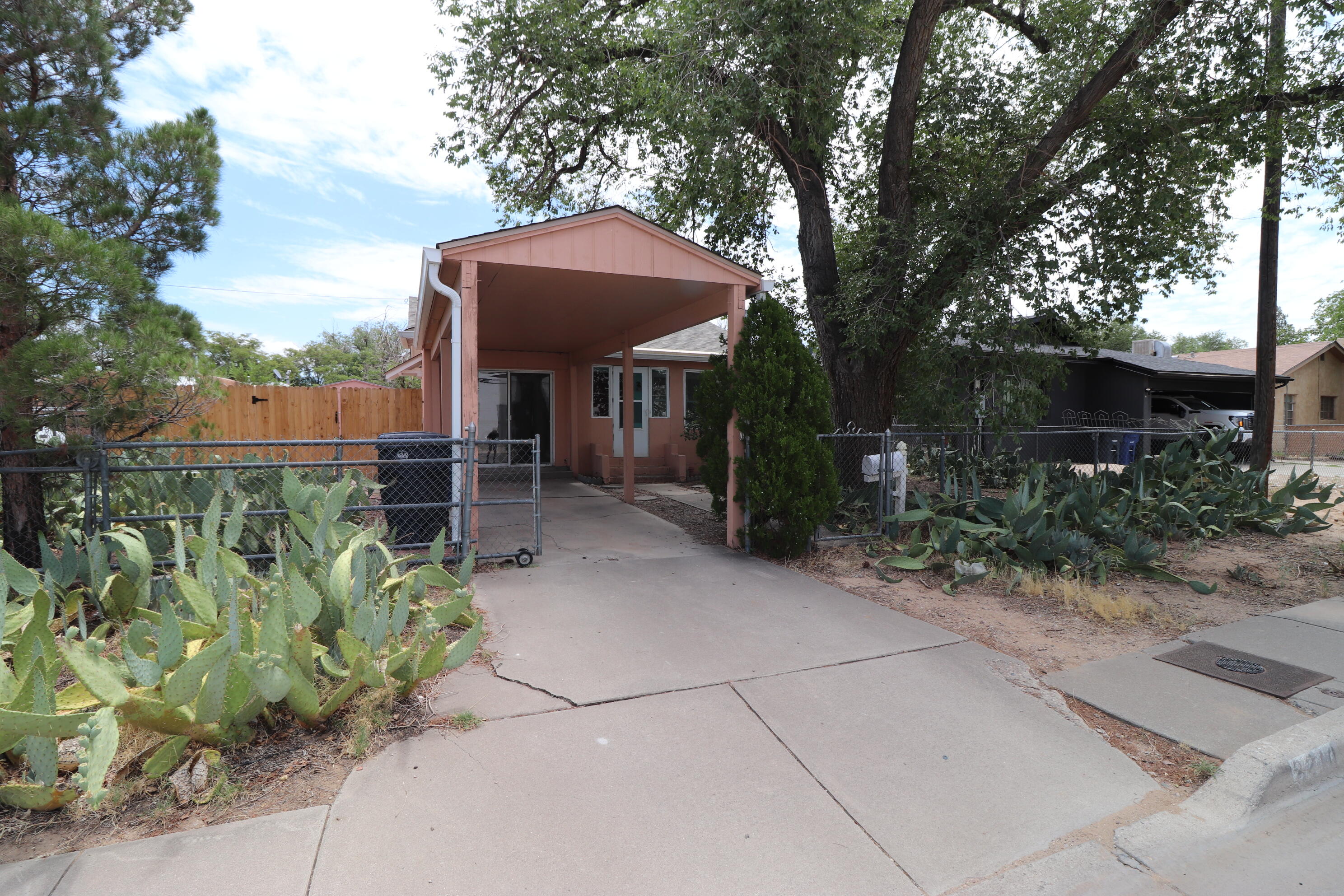 Special financing available!! Tons of potential on this large lot. Convenient location with 2 car deep carport for off street parking. Gated driveway & fenced front yard. Kitchen and bath have been remodeled. Electrical and plumbing has been upgraded. Kitchen has a classic built-in hutch.  New toilet and hot water heater in 2020.  Roof and evaporative cooler replaced in 2024.  New wood fence installed in 2024.All appliances stay including refrigerator, washer, and dryer.  North side access is possible to large backyard. Storage shed with electrical was used as studio/workshop.  Hardwood floors in living and one bedroom. Second bedroom/Family room has gas fireplace and W/D.