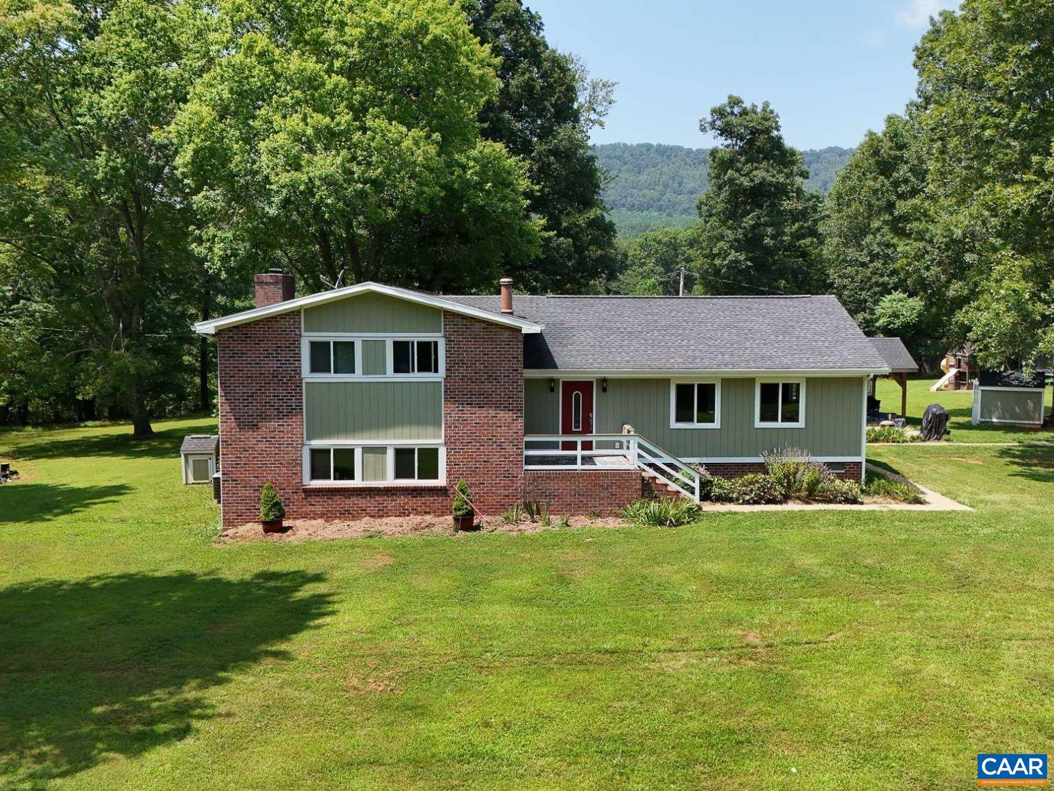 Tucked away on 10 private acres in Albemarle, this lovingly updated tri-level home offers the perfect escape from the norm. Complete with breathtaking mountain views, it's ideal for your mini farm dreams. With 4 bedrooms and 2 full baths, there’s room for everyone inside and out! The main level features gorgeous hardwood floors, soaring ceilings with exposed wood beams, and a spacious, light-filled kitchen with a walk-in pantry and built-in coffee bar. The lower level includes a cozy family room, laundry area, and generous storage space, plus walk-out access to the backyard that craves to entertain under a sky full of stars. Upstairs, the primary suite is a true retreat with a massive walk-in closet and a private balcony to see mountains in the distance. Enjoy smore's by the built-in fire pit, tend to your above-ground garden beds, or gather fresh eggs from the chicken coop in the field. HUGE Trex back deck! A charming cottage with available plumbing would be an ideal workshop or creative space. Fiber optic internet keeps you connected, while the privacy of this property gives you a sense of peace. 10 acres, a spacious home and super private is perfect for the homesteader at heart ready to be surrounded by nature.