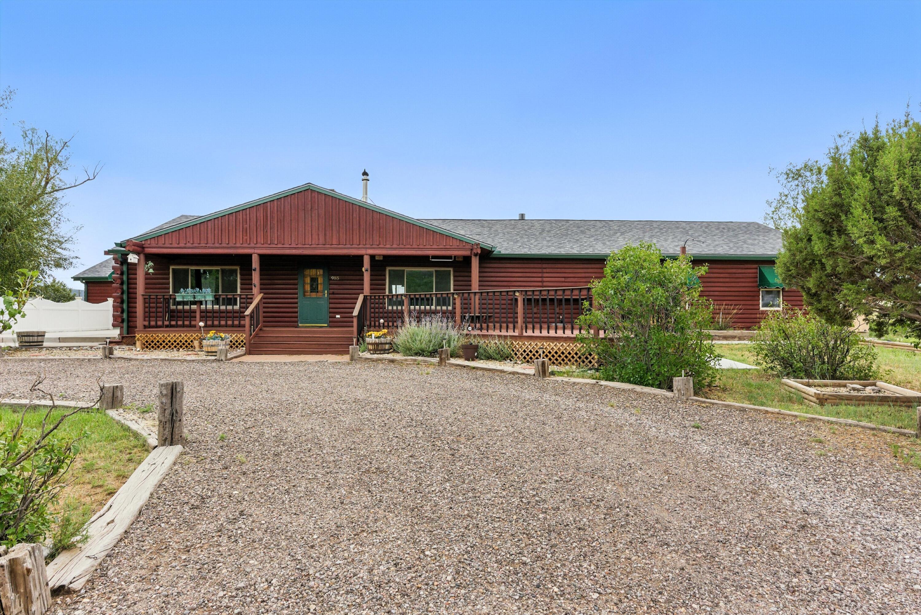 Situated on 2.5 peaceful acres, this charming 2921 sq ft log cabin offers a perfect blend of rustic comfort and modern amenities. Featuring 4 spacious bedrooms & 3 bathrooms, it provides plenty of room for family & guests alike. The inviting brick fireplace is a cozy focal point in the living area, while the oversized 3-car garage offers ample storage and workspace.  You'll love the updated kitchen with stainless appliances and plenty of counter space. Caressed by  lovely trees, this home combines tranquility with tons of space, including two storage buildings  for all your toys!  Enjoy sipping coffee on the expansive deck!  Only minutes to easy I40 access and Edgewood. The location is perfect for those wanting country life but want to be close enough to town for work or play.