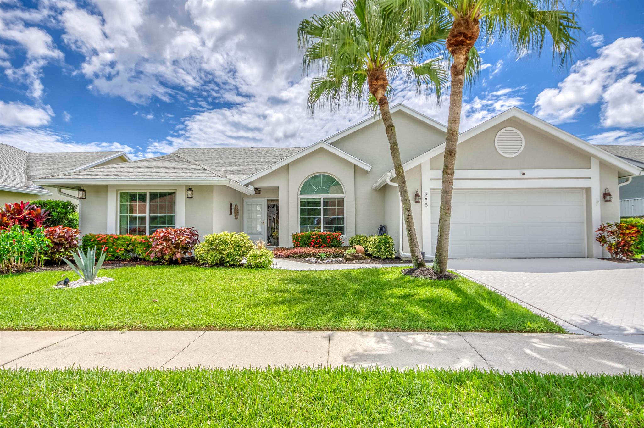 An incredible find in a hidden gem of a community! Welcome to this updated and inviting home with new kitchen and new bathrooms, natural light throughout and soaring vaulted ceilings. The east-facing, screened lanai takes in the morning light and has more than enough space for the jacuzzi tub, fire table, conversation sitting set, or put in an in-ground pool if you choose! More inconspicuous updates are the new electrical box,  2021 water heater and impact window. This well-managed and manicured community has a low HOA fee, covering your lawn care, cable, internet, and the community pool. 5 minutes to all major conveniences, 20 minutes to PBI Airport, 15 minutes to the beach.
