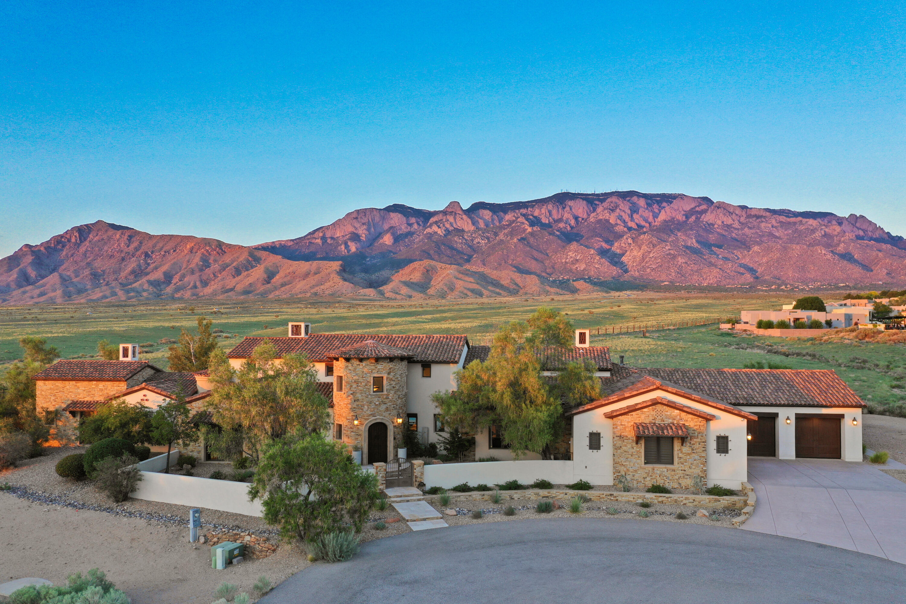 Rare opportunity to own a true masterpiece beside the private Sandia Pueblo buffalo preserve. This elite estate offers unmatched seclusion, breathtaking views, and cutting-edge technology paired with extraordinary craftsmanship. Features include a Juke Audio sound system, Lutron lighting, hand-scraped Hickory floors, custom knotty alder cabinets, arched brick ceiling, exposed wood trusses, Quartzite countertops, stone accents, and Spanish-imported roof tiles and entry door. The pool and hot tub perfectly frame the Sandia mountains creating the ultimate backdrop.  Additional exterior features include a firepit, outdoor kitchen, and covered patio with fireplace. A detached casita enhances the private entertaining space. Fully furnished for the discerning buyer seeking unparalleled luxury.
