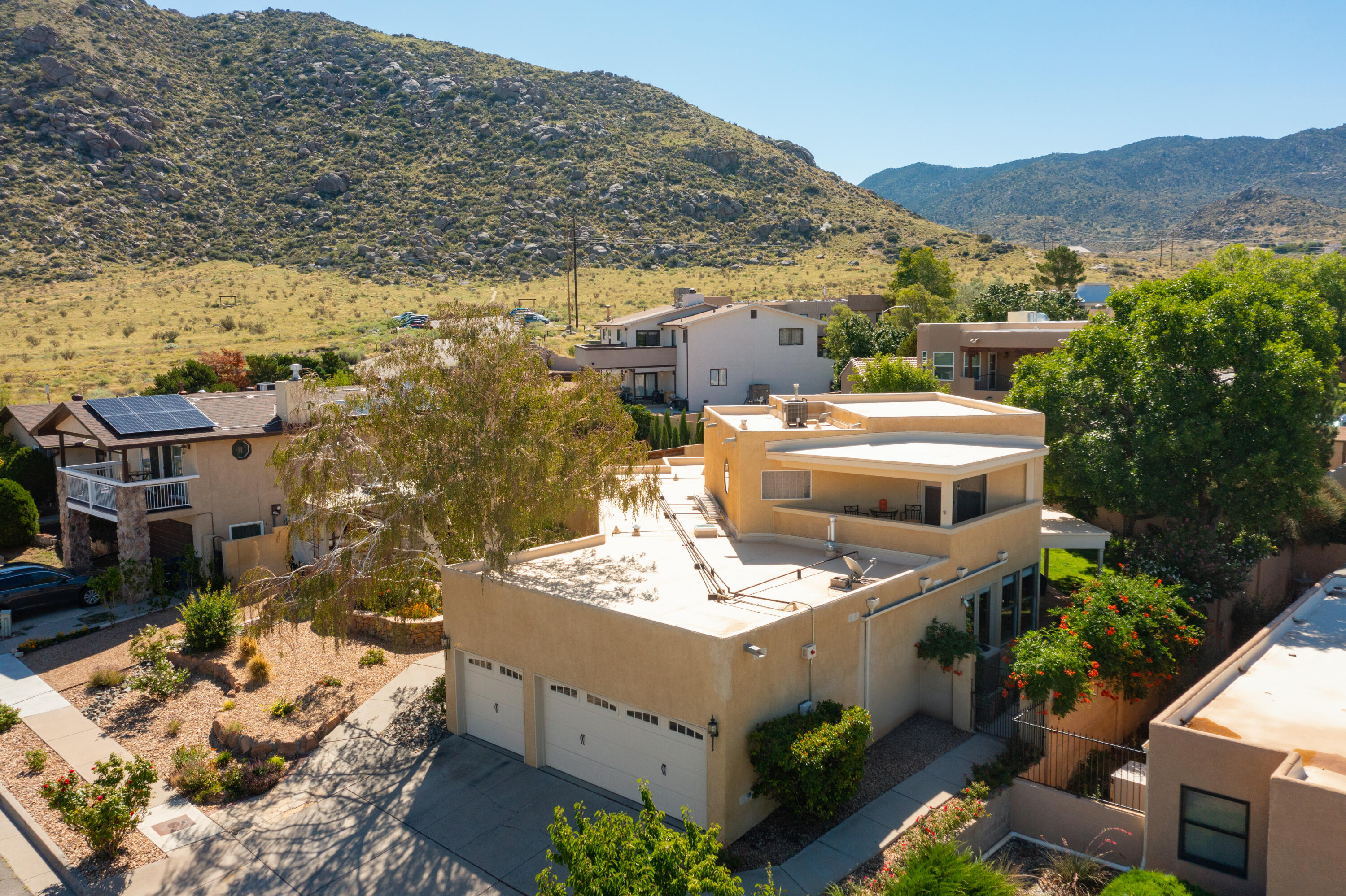 Location Location at the edge of the majestic Sandia Mountains!  This 4 bedroom, 3 car garage, w/self cleaning, heated pool & hot tub has it all. Natural light floods the open floorplan making it that much more special & bringing the outside in! The beautiful landscaping, both front & back, add to the appeal.  Many many upgrades include a new TPO Roof w/warranty (2020); some newer windows; new electric (battery operated) blinds; 2 refrigerated units (2021); brand new attractive laminate flooring in major living areas.  The expansive primary suite enjoys lots of privacy; his & her closets & a beautiful deck for enjoying the sunset.  Primary bath recently updated.  Downstairs are 3 additional bedrooms plus updated baths. The kitchen feautures updated granite countertops (MORE)