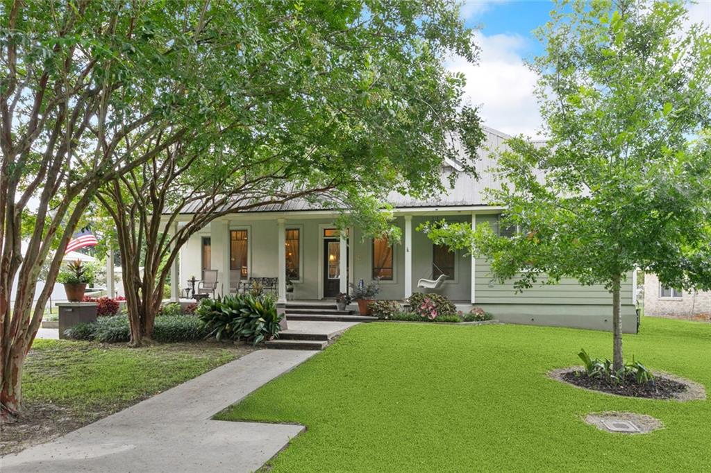This beautifully crafted, custom-built home is truly one of a kind—offering charm, comfort, and thoughtful design both inside and out. Nestled in an X flood zone just along the Mississippi River, the home features 4 bedrooms—2 on the main floor with 1.5 baths and 2 upstairs connected by a full bath. The heart of the home is the spacious kitchen, complete with a large island, granite countertops, stainless steel appliances and custom cabinetry. A formal dining and living area sits just off the kitchen for easy flow during gatherings. Throughout the home, you'll find stained and scored floors, elegant Pella wood windows, and quality finishes that add warmth and style. The primary suite is a relaxing retreat featuring two custom closets, linen closet, dual vanities, luxurious soaker tub, and a spacious walk-in shower. Step outside to enjoy your own backyard oasis—lush landscaping, whimsical fountains, and vibrant greenery surround the home, creating a peaceful, park-like atmosphere. Both the front and back porches offer tranquil spaces to relax or entertain. The 3-bay garage is an impressive bonus with its own full kitchen, full bath, and electric vehicle outlet—perfect for guest quarters, entertaining, or a workshop. Additional highlights include: Tankless water heaters, Storm shutters, 2 laundry rooms; in the main house and in the garage, and ample attic space for storage. All appliances stay, including washers and dryers. This is a rare opportunity to own a truly special home...Don’t miss your chance to make it yours!