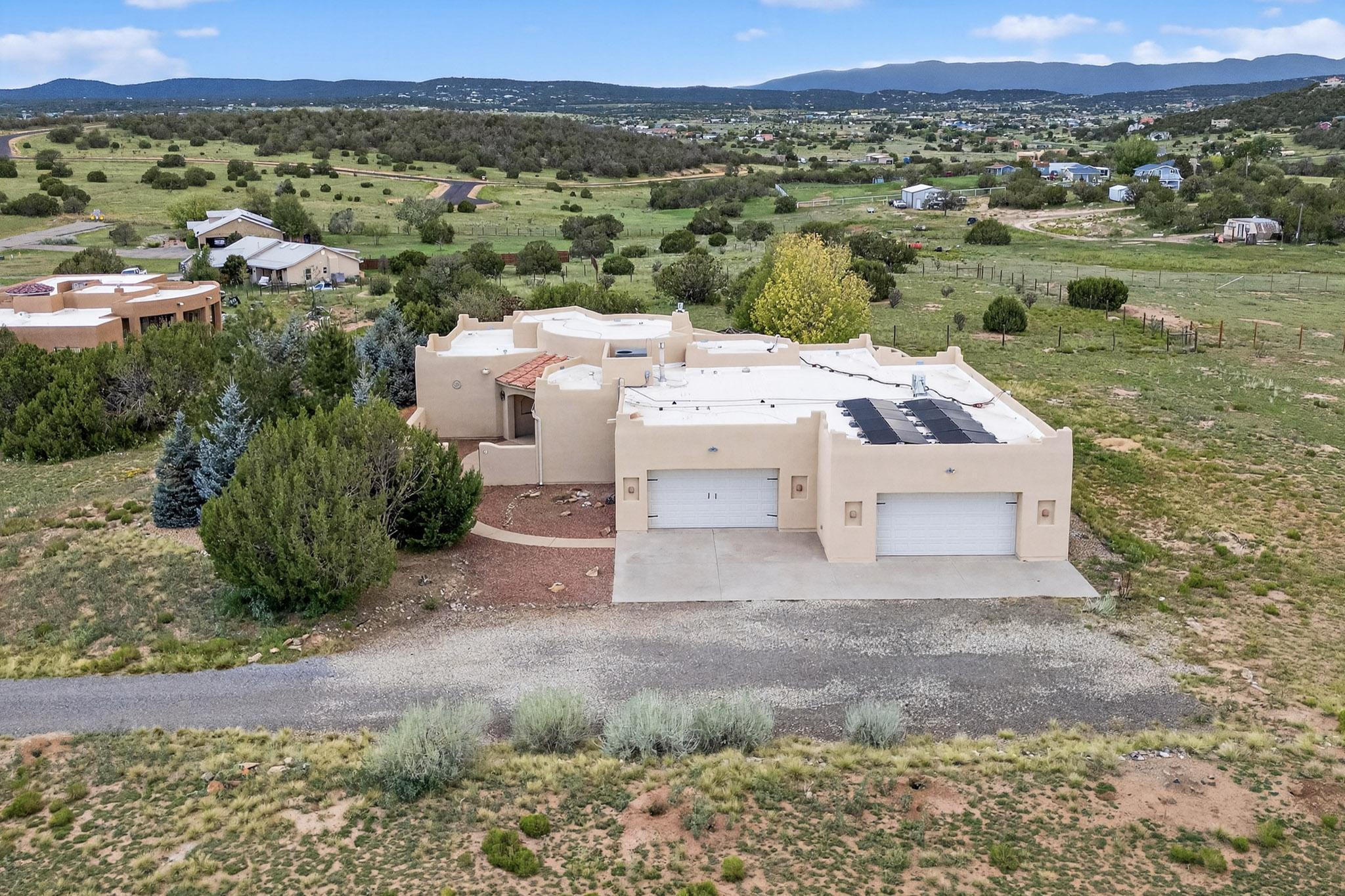 Charming southwestern-style home on two acres with mountain views! Enjoy fresh mountain air on the patio while you have your coffee, or relax in the hot tub after a long day.TPO Roof installed August 2024 (incl warranty)Entire home (incl surrounding wall) stucco replaced November 2024Original extra 4-car garage (appx 1000 sf) has been outfitted as a heated and cooled multi purpose room, with 3/4 bath, and a large walk-in closet. Use as garage, workshop, studio, or additional living space use. Refrigerated air Aug 2020.Two mini-splits in multi-purpose room/garage, and PBR Aug 2019 AND owned solar panels will reduce utility bills!
