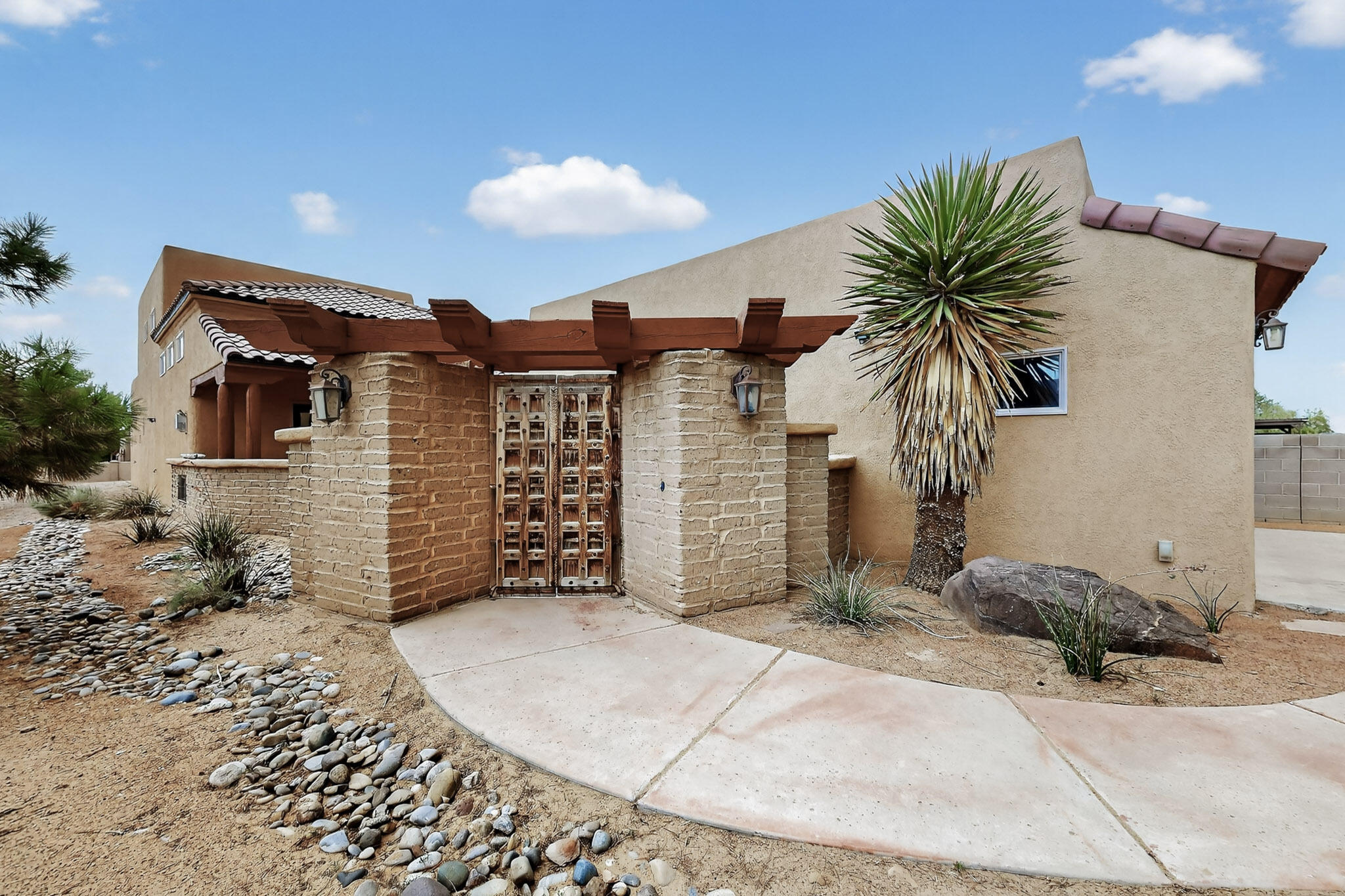 From the moment you arrive, the gated front courtyard with imported wooden doors invites you into a peaceful and private outdoor space with incredible mountain views. Inside you'll discover raised tongue-and-groove ceilings, stamped colored concrete floors, and travertine countertops that add warmth and texture throughout.  The open floor plan is spacious and inviting, with every room offering generous dimensions and intentional design. This home is packed with upgrades, modern features, and unique architectural touches that set it apart from the rest.  Additional features include refrigerated air, an oversized garage, and two covered patios--perfect for enjoying golden hour mountain views or weekend BBQs with friends. With views, upgrades, and room to grow, this is a true gem!