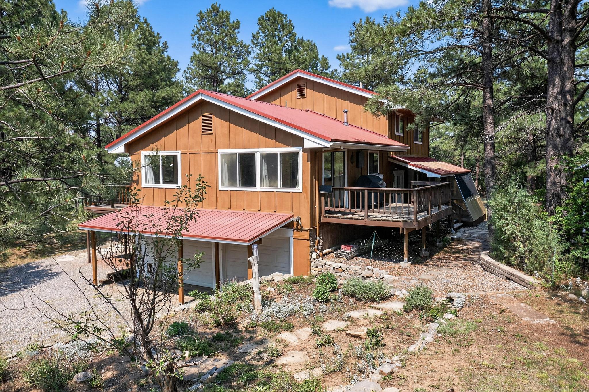 Imagine relaxing at your own 3,700 sq ft 3 bedroom, 4 bath, secluded mountain retreat home with: 3 gas fireplaces; office space; sunroom/cold-frames; walk-in basement entertainment room, bonus room & walk-in closet; thermal windows; 3 decks; attached garage and carport plus detached metal, barn-style garage for RV/boat. Situated on 2.3 acres of relatively flat, arable land, lends itself to self-sustained ''homestead'' living; perfect for horses or goats. Other included outbuildings: a porched, heated/cooled art studio; fully functional greenhouse; and a ''poultry resort''. Flagstone walkways lead to grassy or wooded sitting areas, and extensive raised flower & vegetable beds on the estate - all only 30 minutes from Albuquerque, in Tijeras, NM. Roads are paved and county maintained.