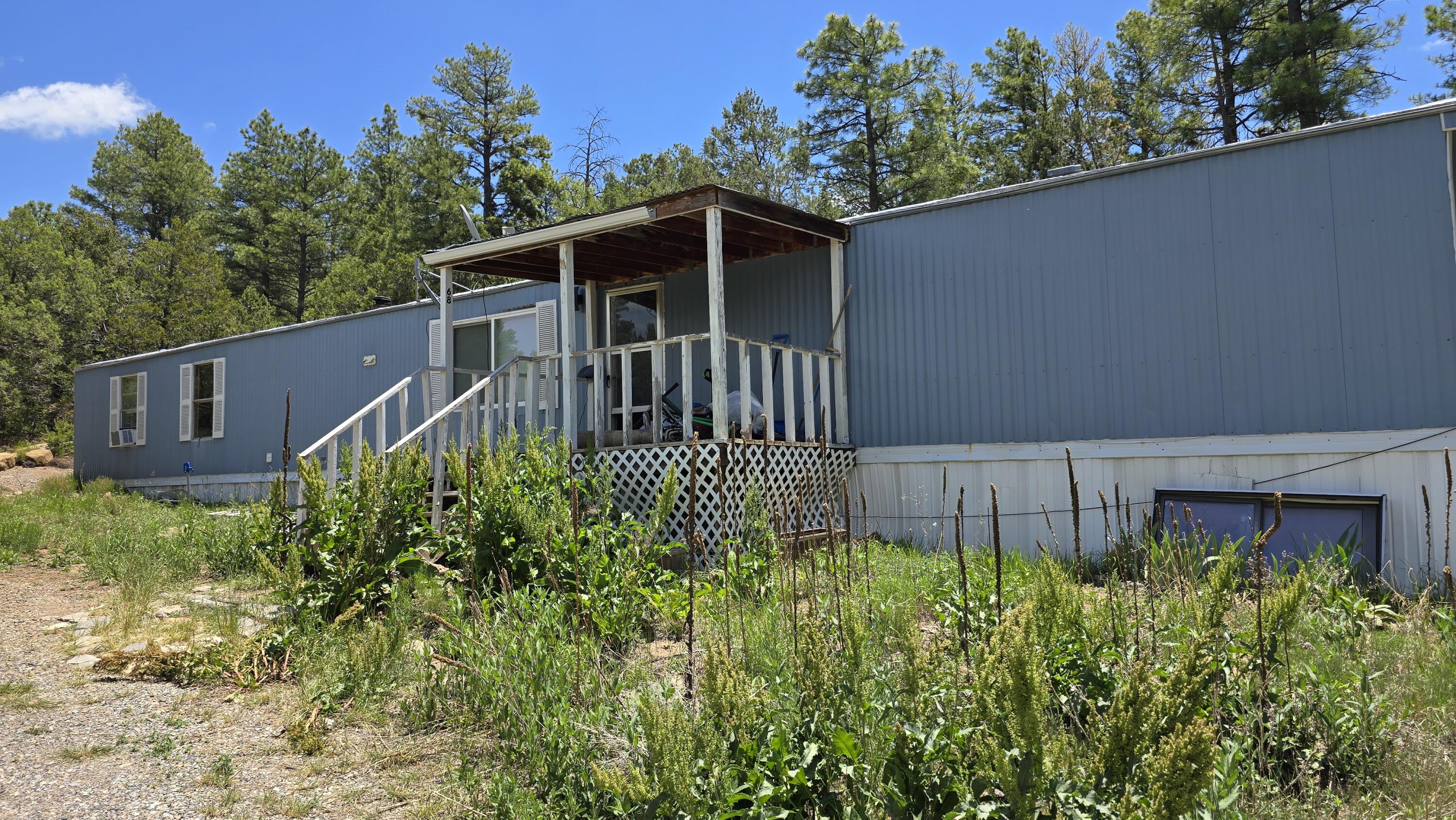 Beautiful wooded 2 acres just 25 min from Albuquerque! Includes manufactured home with 3 bedrooms, 2 full baths and an open living/dining/kitchen concept! Furnace and water heater 3 yrs old, private well with 500 gal storage tank. Screened back patio too!