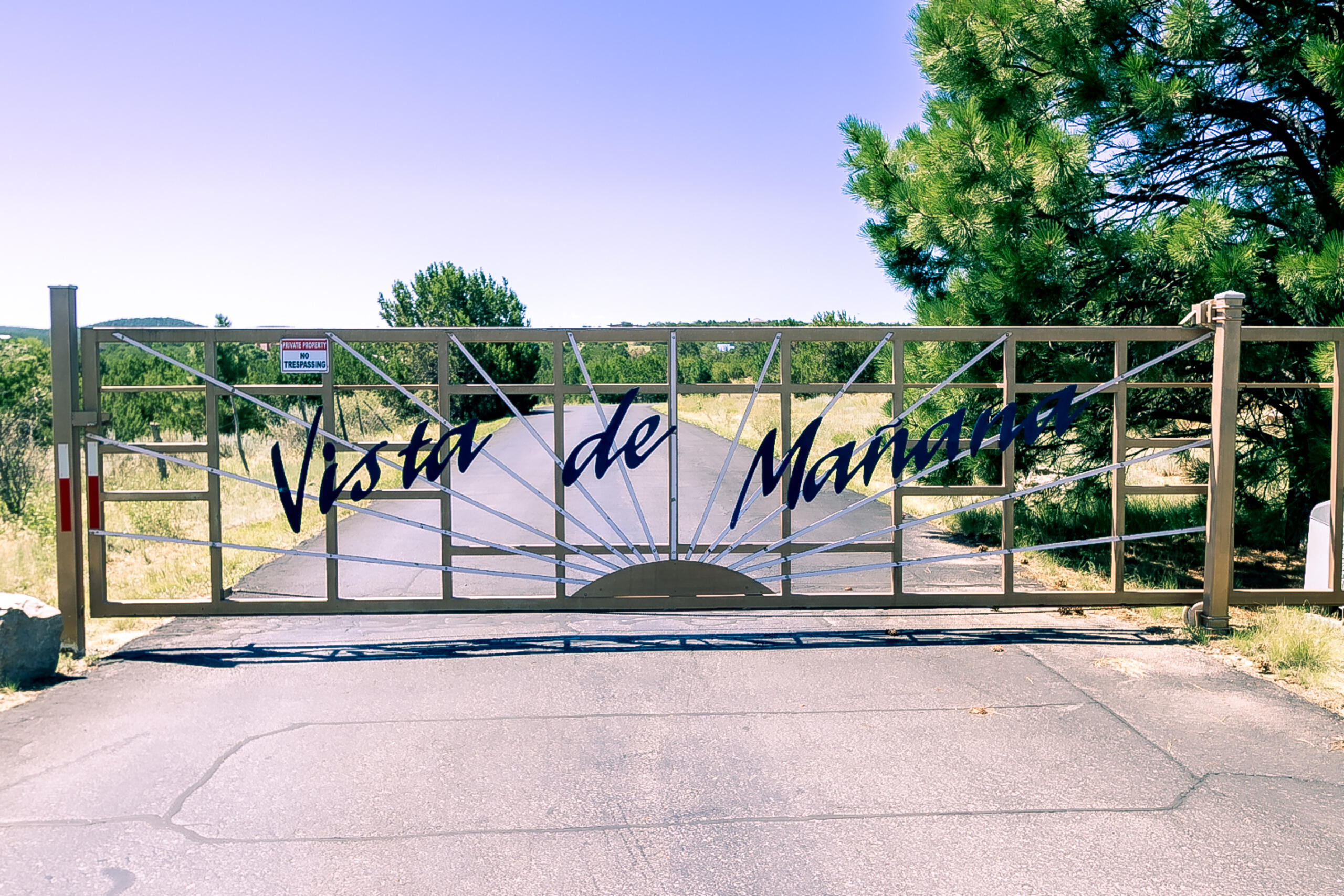 Custom-built Northern New Mexico style home located in a gated community on a cul-de-sac with paved roads to the property. The home includes a pitched metal roof replaced in 2019, a seller owned 9.6 kW solar system ~1.5 years old, and energy-efficient mini-split systems throughout ~1.5 years old. The main level is constructed of adobe, providing thermal insulation, and features stained concrete flooring. The kitchen includes shaker-style cabinets, under-cabinet lighting, updated granite countertops, a food prep island, and a built-in pantry. The adjacent dining area offers built-in cabinetry and a china hutch with a butcher block countertop. The living room has a gas stove with a custom wood mantle. The solid oak staircase includes built-in drawers and leads to the upper level.