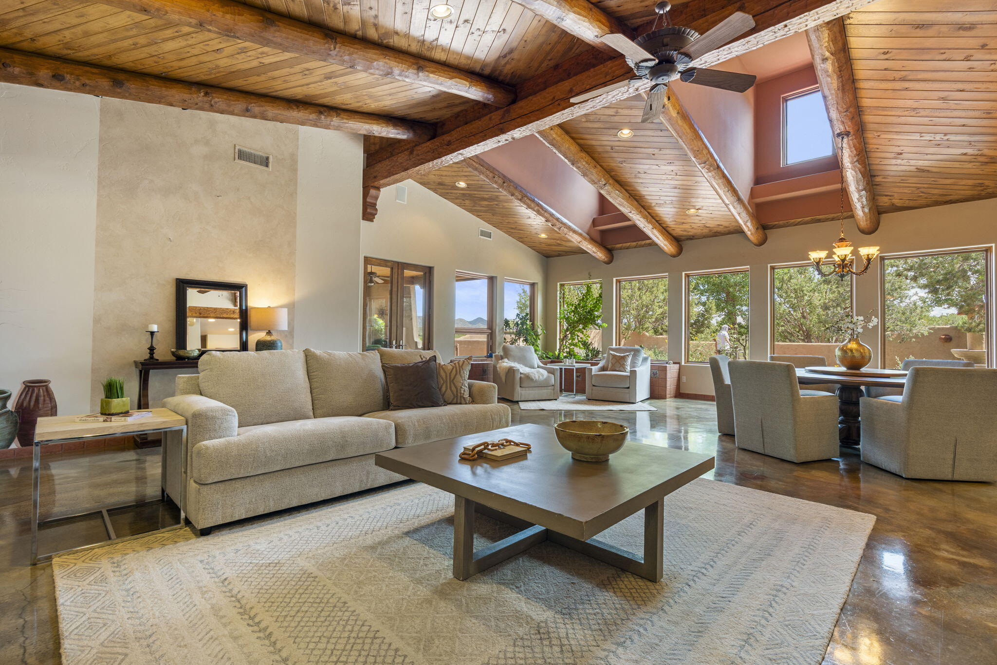 Artistic Mountain Home set on 10.14 private acres in San Pedro Creek, this distinctive 4 bedroom, 4 bath home is a true work of art- blending traditional Northern New Mexican design with creative, custom craftsmanship throughout. Built to inspire, the residence features expansive open-concept living with polished concrete floors, a dual-sided fireplace connecting the living and library areas, and large windows that frame panoramic views of ridges and endless skies. The kitchen is warm and welcoming, with artisanal cabinetry, handcrafted tile, and a layout that encourages gathering and creativity. The home features two separate bathrooms and walk-in closets within the primary bedroom making this space truly one of a kind! As you walk through, you'll be surrounded by beauty from the