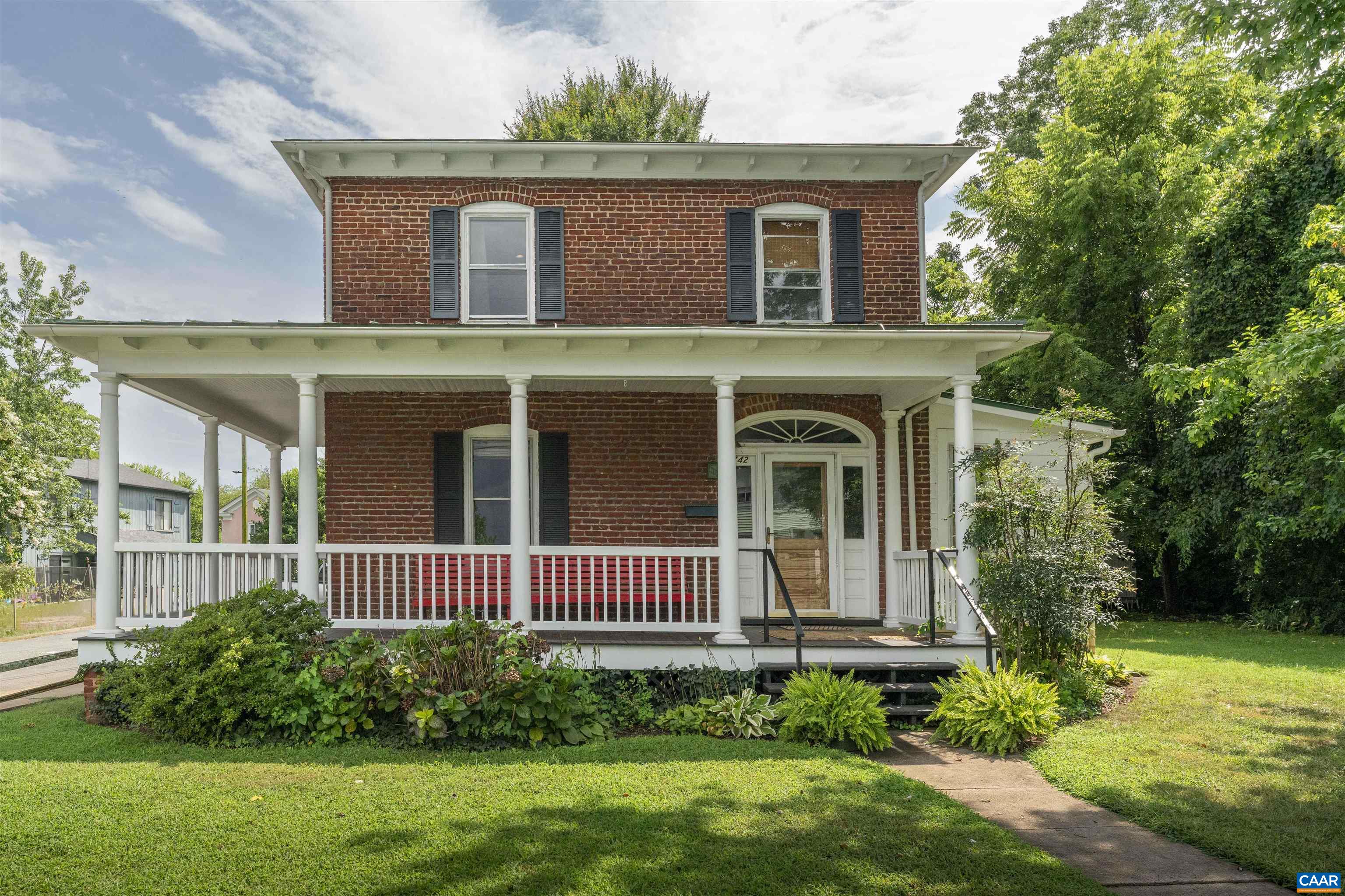 1920 Brick Farmhouse in supremely walkable downtown Belmont. Historic home renovated by an artisan woodworker with local black walnut flooring in the kitchen, custom built in bar, window trim, and accents throughout. Original brick chimney, heart pine floors, and trim throughout preserve the charm and character while renovated kitchen and baths make it functional for modern living. Wrap around porch and main floor with open concept  dining/living/kitchen make it the perfect home for entertaining before walking to a night on the town. Half bath and laundry complete the main floor. Upstairs is comprised of 3 bedrooms and full bathroom with custom tile shower and soapstone topped vanity. The most desirable location in Charlottesville. Leave your car at home and walk around the corner to Charlottesville's best restaurants in downtown Belmont or one block to live music, restaurants, and shops on the downtown mall. Off street parking accessed off Goodman.
