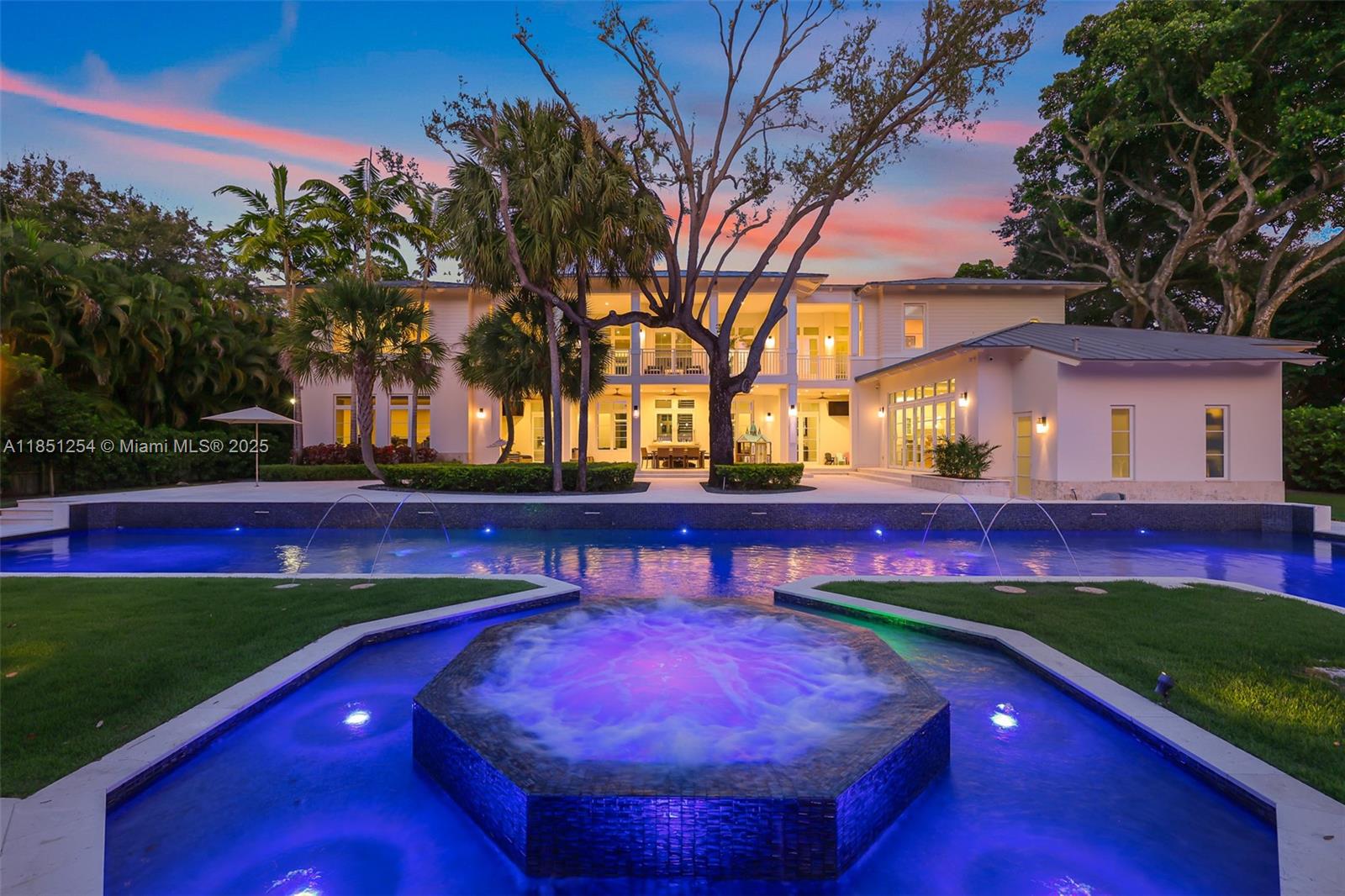This breathtaking custom two-story estate sits on an acre of beautifully landscaped grounds in the prestigious Village of Pinecrest. Spanning over 13,000 total square feet, it offers 8 spacious bedrooms and 10.5 luxurious bathrooms. Inside, you'll find wood accents, soaring vaulted ceilings, and a temperature-controlled wine cellar. The gourmet kitchen showcases top-tier appliances, while a smart home system enhances everyday convenience. The resort-style backyard is designed for both relaxation and entertaining, featuring an Olympic-sized lap pool with underwater speakers, a summer kitchen, basketball court, and private guesthouse with a full kitchen and bath. Just minutes from top-rated schools and scenic parks, this exceptional estate embodies refined South Florida living.