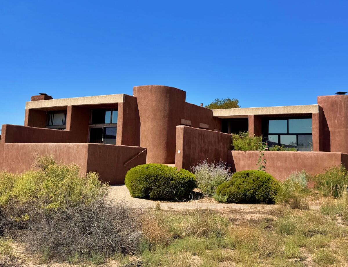 Exceptional home in the Modernist adobe community of La Luz, which sits on over 40 acres Forever Open Space along the Rio Grande Bosque. 13 Arco Ct had only one owner during its historic lifetime--you can be the 2nd. What sets it apart: breathtaking Mtn/Bosque/City views from inside the home & from the wraparound front courtyard. Built with 16'' adobe walls, the home is finished with brick floors & plate-glass windows spanned by cast-concrete lintels; plus T&G wood ceilings, four skylights & a dramatic wood fireplace. See the 3D Tour! There's an ante-room between two bedrooms, for floorplan flow. Outside your private courtyard are acres of manicured Greenspace. On a cul-de-sac, the home is nicely separated from other residences for almost exclusive privacy. Come see!